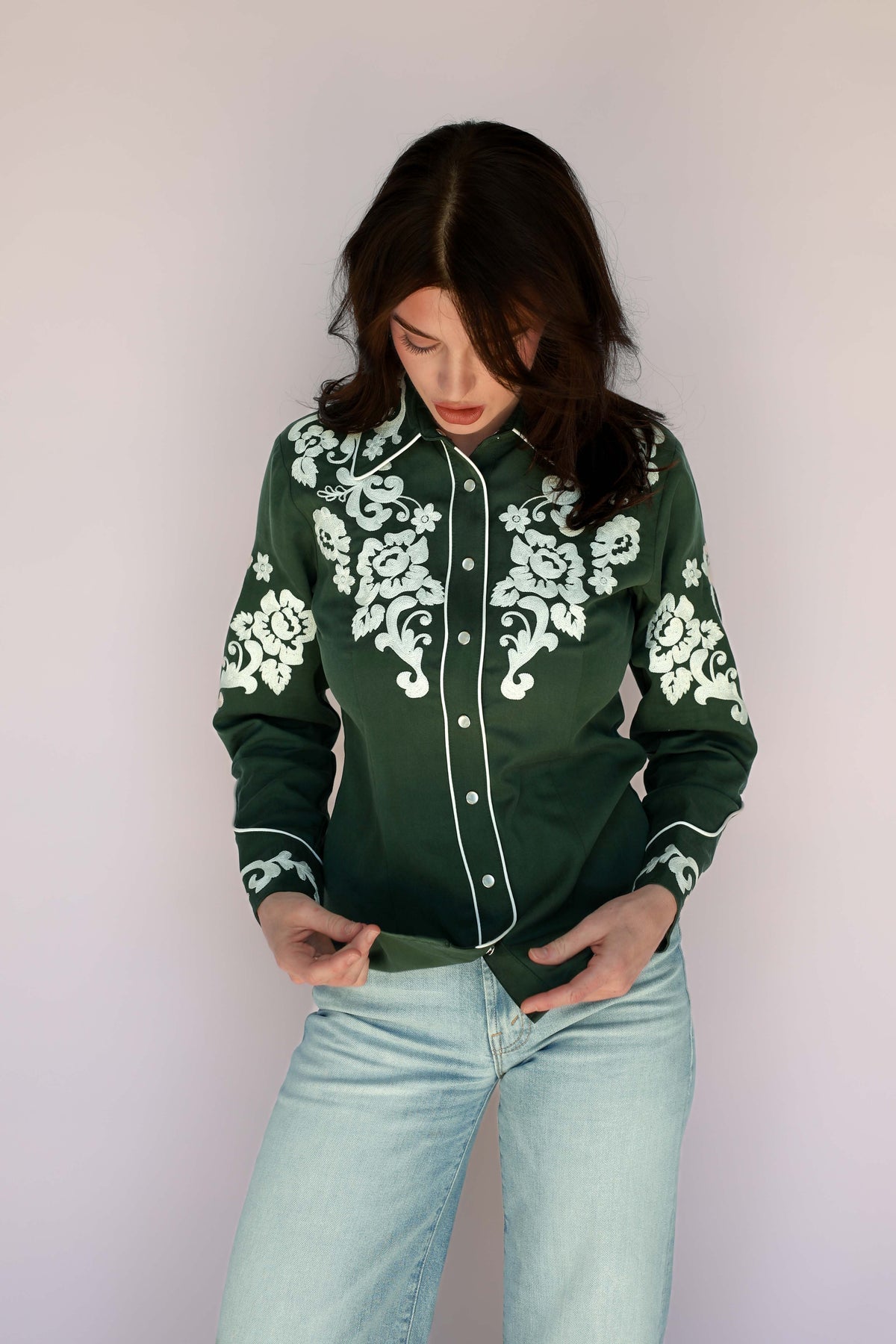 Model in the H Bar C Fort Worth green shirt with white floral embroidery on chest, shoulders, and cuffs.