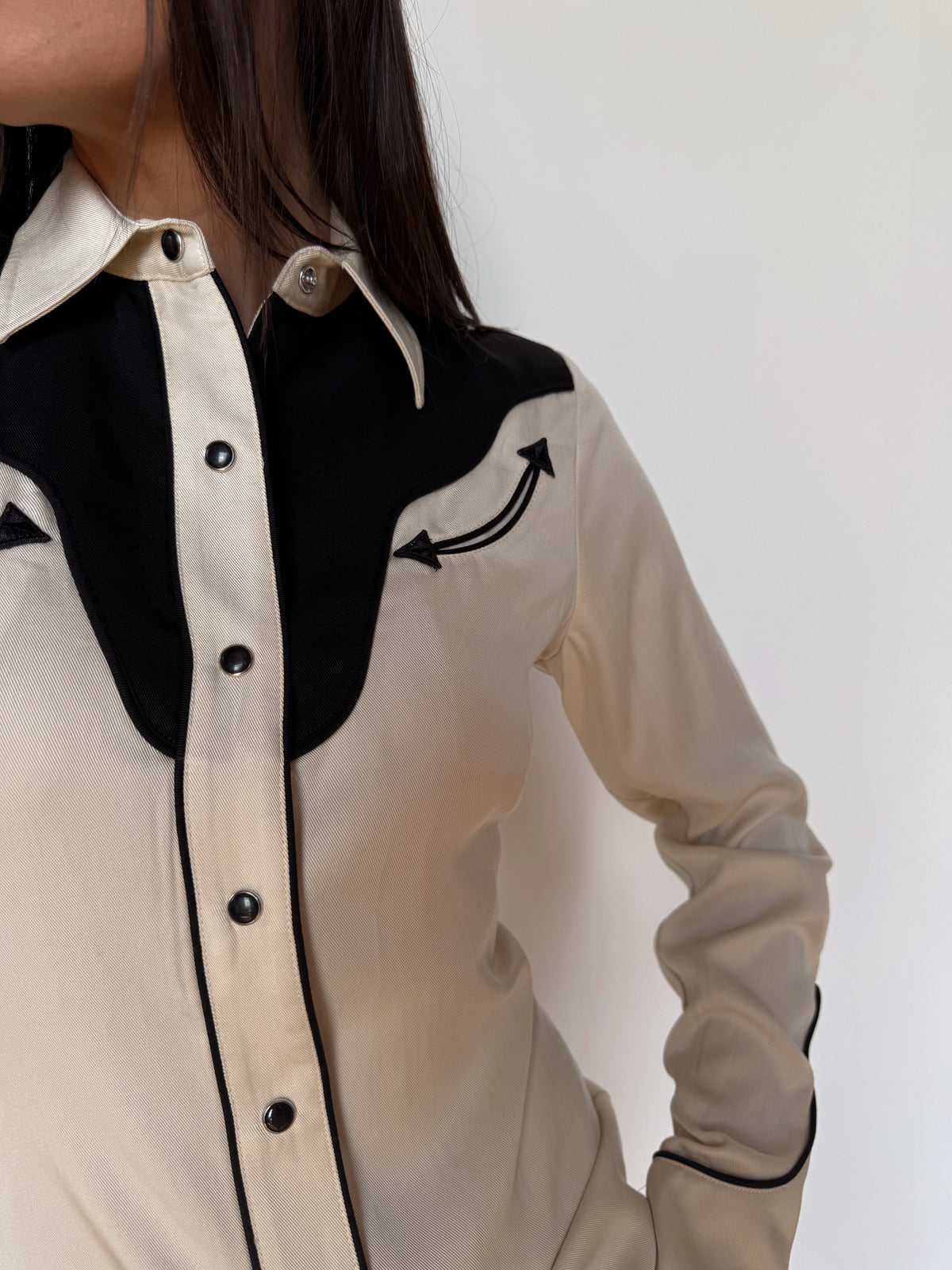 Close-up of the black yoke, piping, and pearl snaps on the H Bar C San Juan women's off white western shirt.