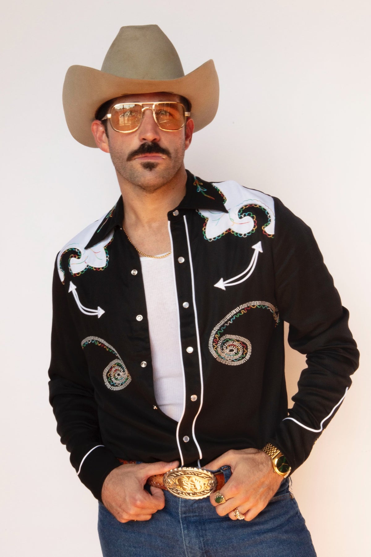 Man in a cowboy hat wearing the H Bar C Arrowhead shirt in black with white embroidery, originally designed for Roy Rogers in 1974.