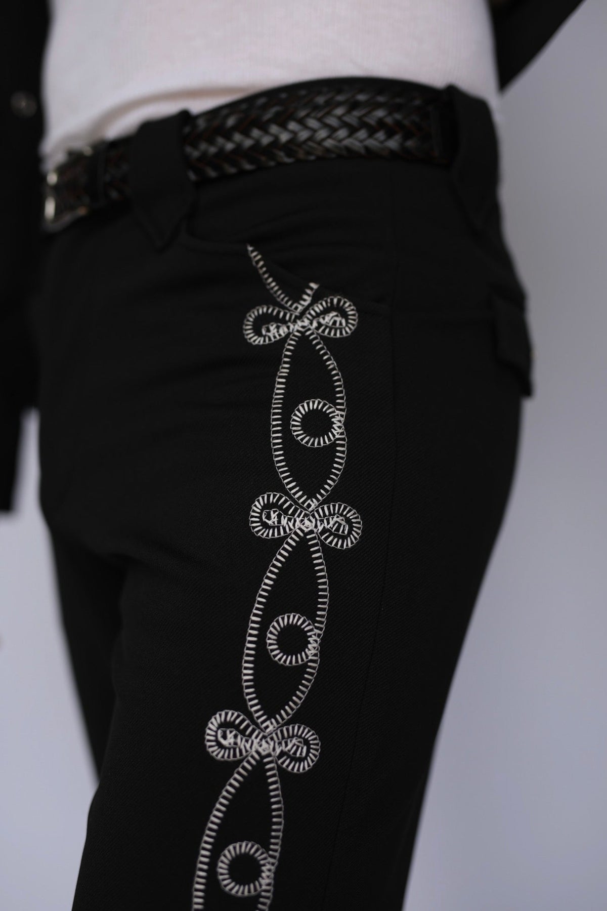 Close-up of the white hand-guided soutache braid on the side of the H Bar C Bolero El Patrón black pants.