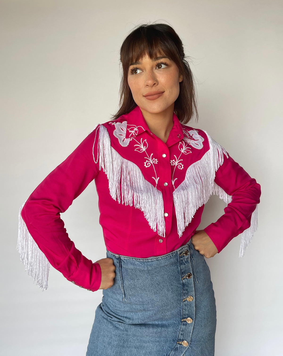 Front view of the H Bar C Taos pink fringe western shirt with white floral embroidery and denim skirt.