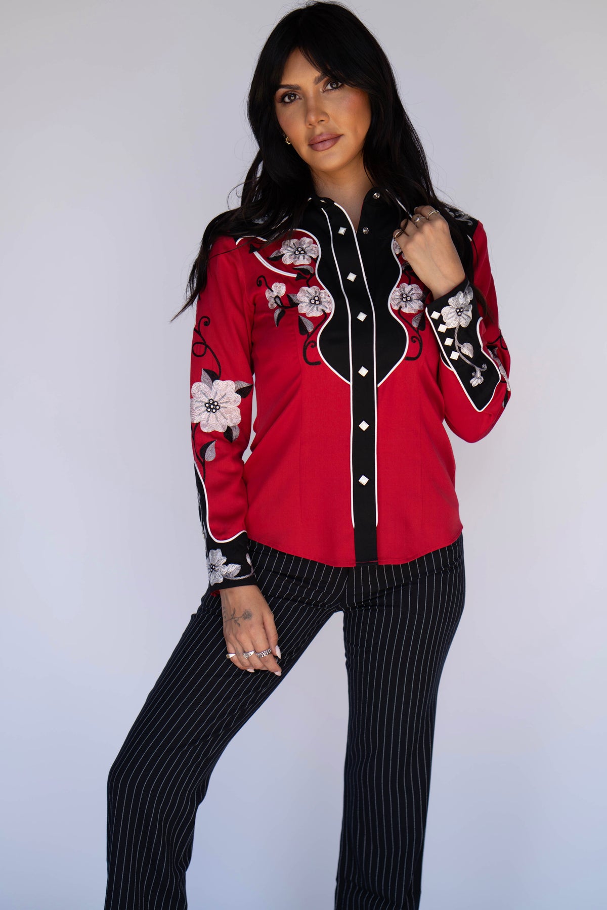 Model in the H Bar C Santa Ana red and black floral embroidered western shirt and pinstripe pants.