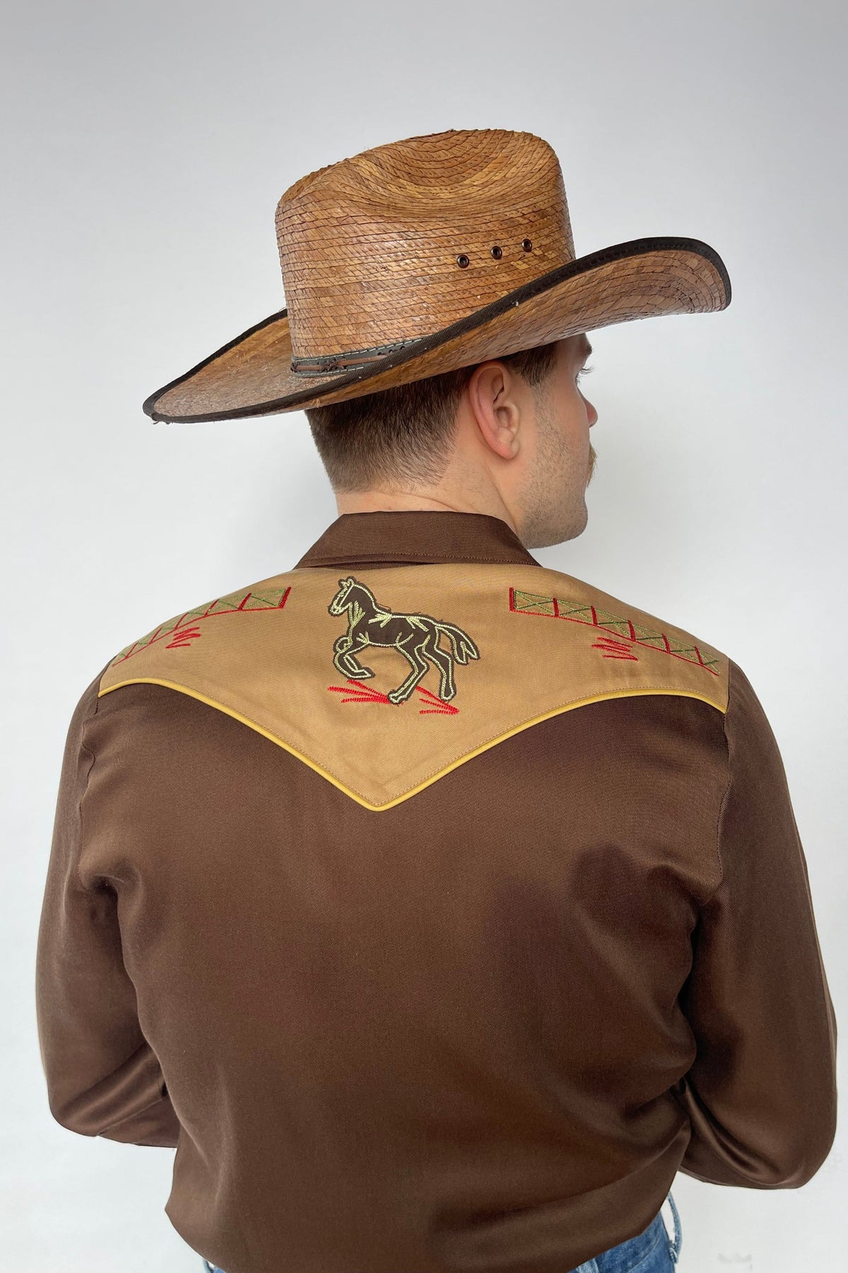 Back view of the H Bar C Bozeman brown western shirt with embroidered horse and rider on the tan back yoke.