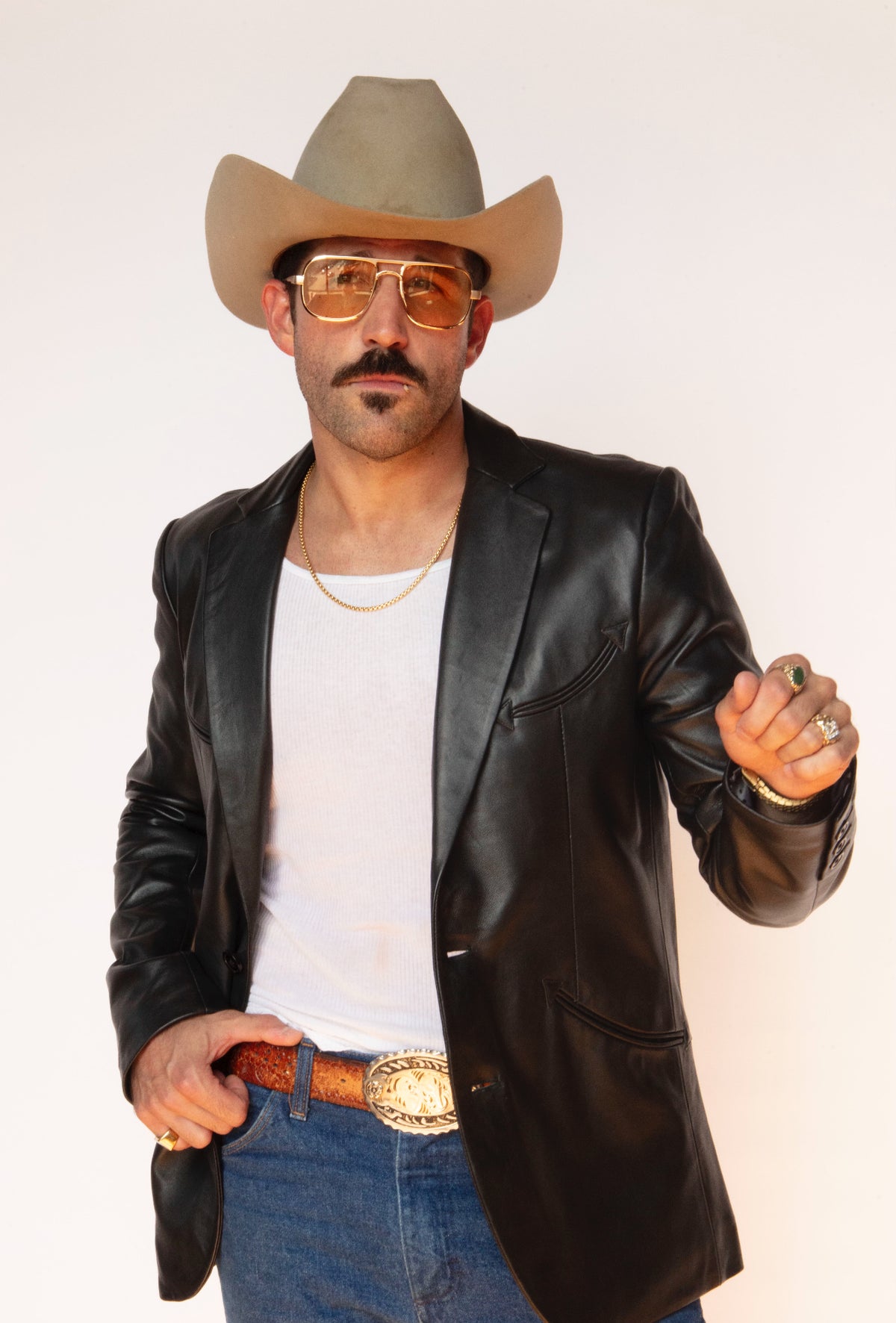 Man in a straw hat and glasses wearing the H Bar C Carson black leather jacket over a white tank.