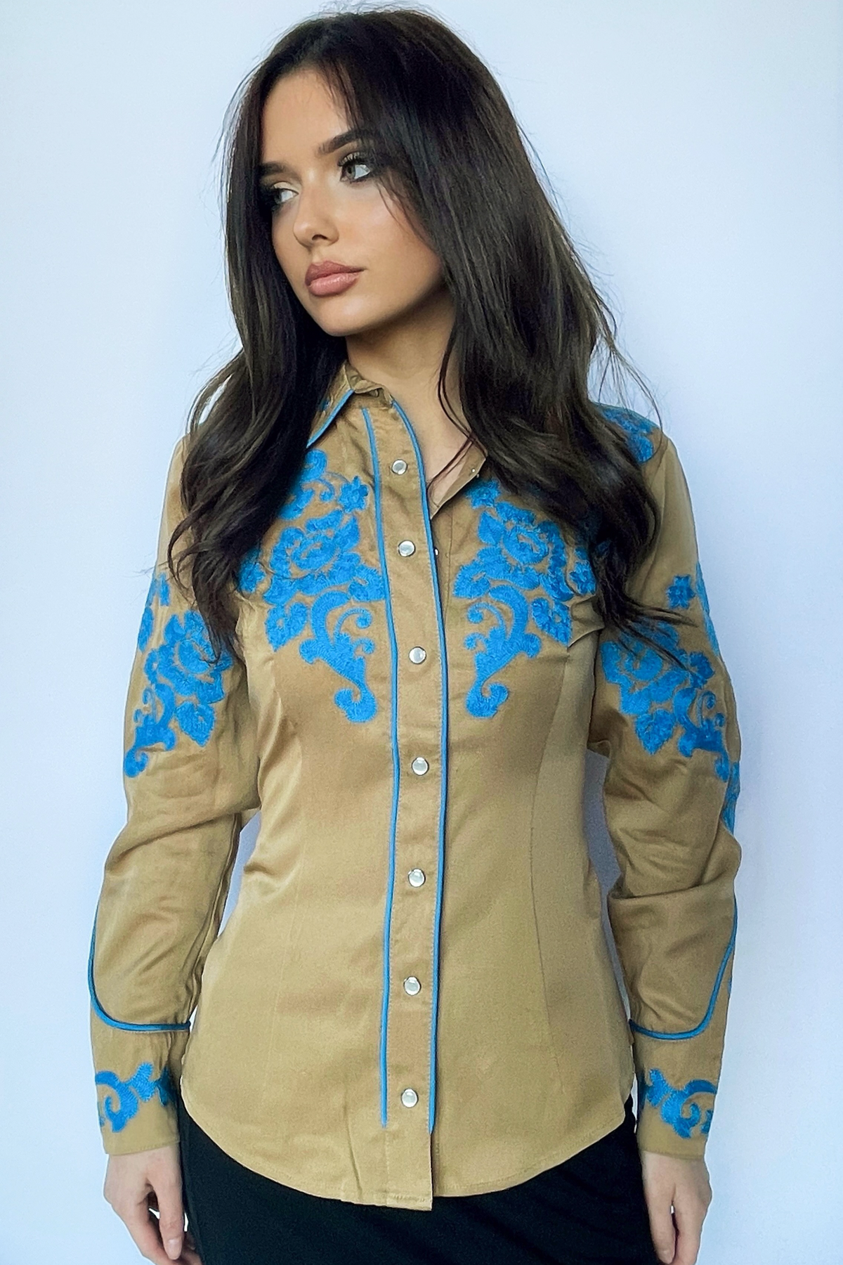 Woman wearing the H Bar C Fort Worth women's shirt in tan with blue chain stitched roses on the yoke and sleeves.