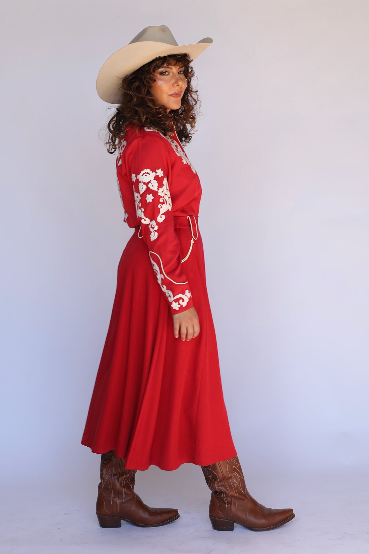 Side view of the H Bar C Santa Fe women's red skirt with full swing and boots.