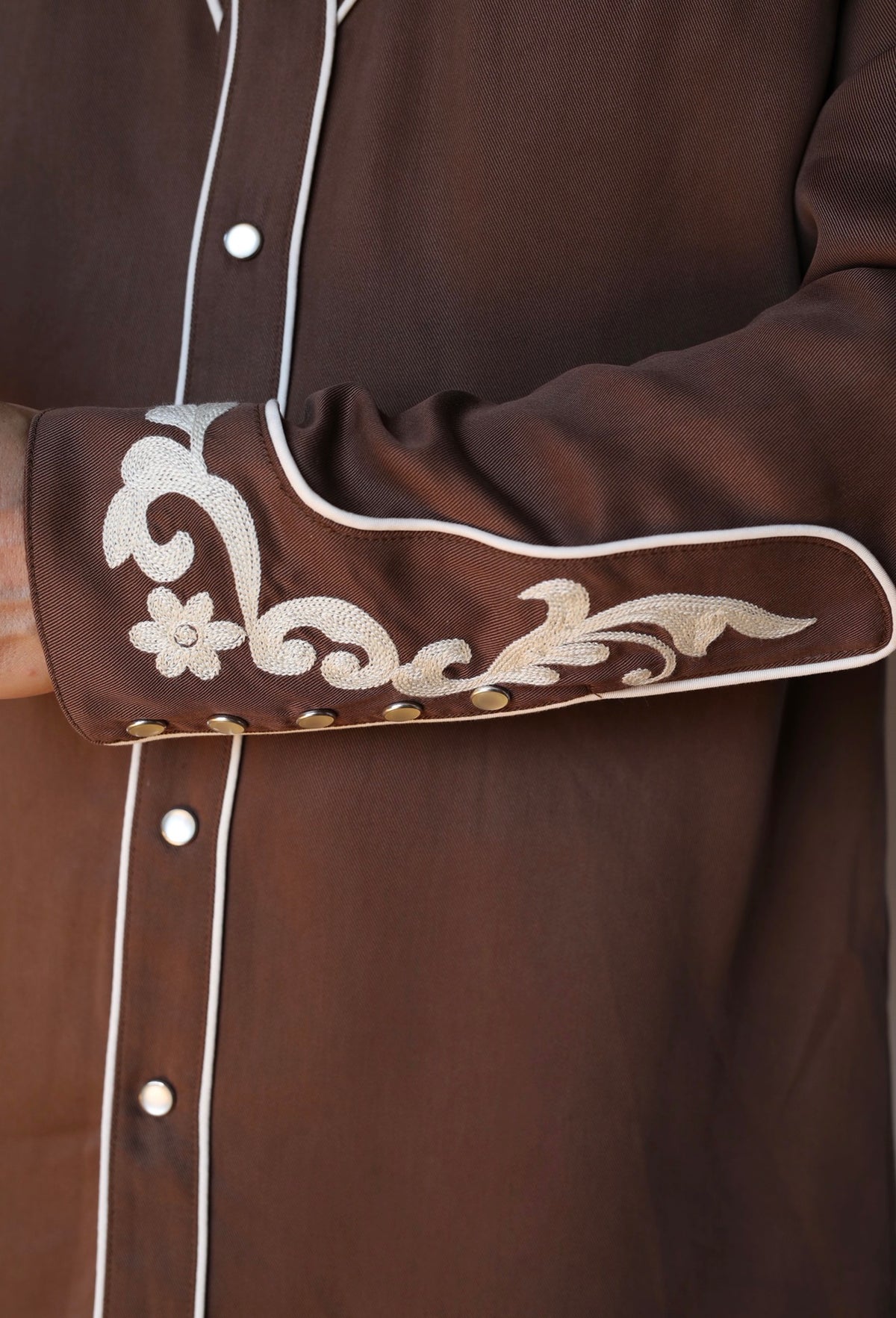 Cuff detail of the H Bar C Durango brown western shirt with cream chain stitch embroidery and pearl snaps.