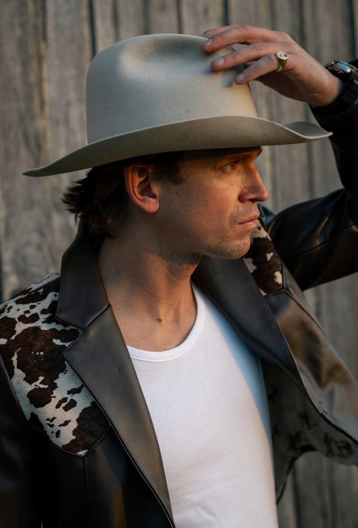 Man in a grey cowboy hat wearing the H Bar C Cody leather jacket with cowhide yoke.