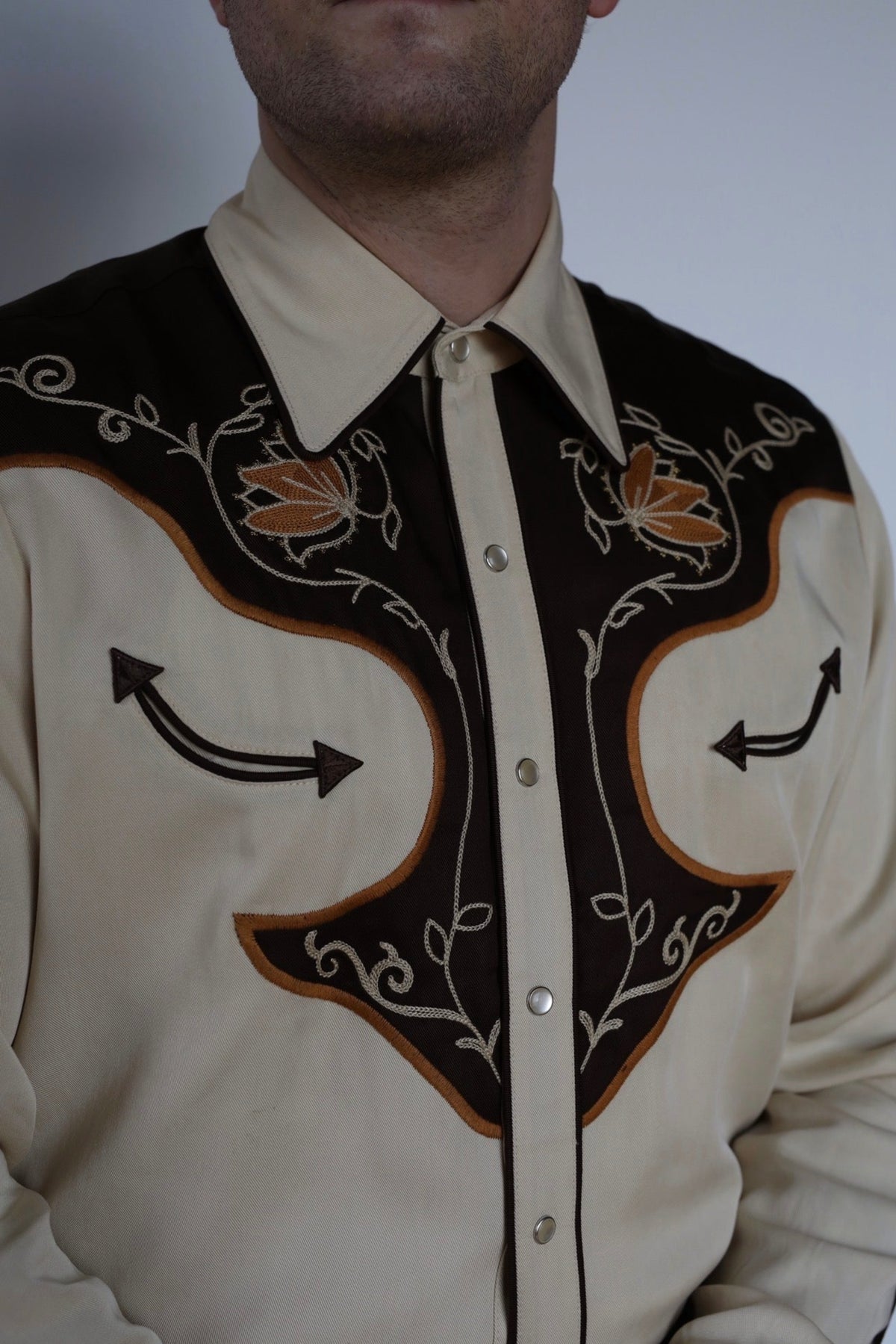 Close-up of the brown yoke with orange and cream embroidery on the H Bar C Santa Barbara western shirt.