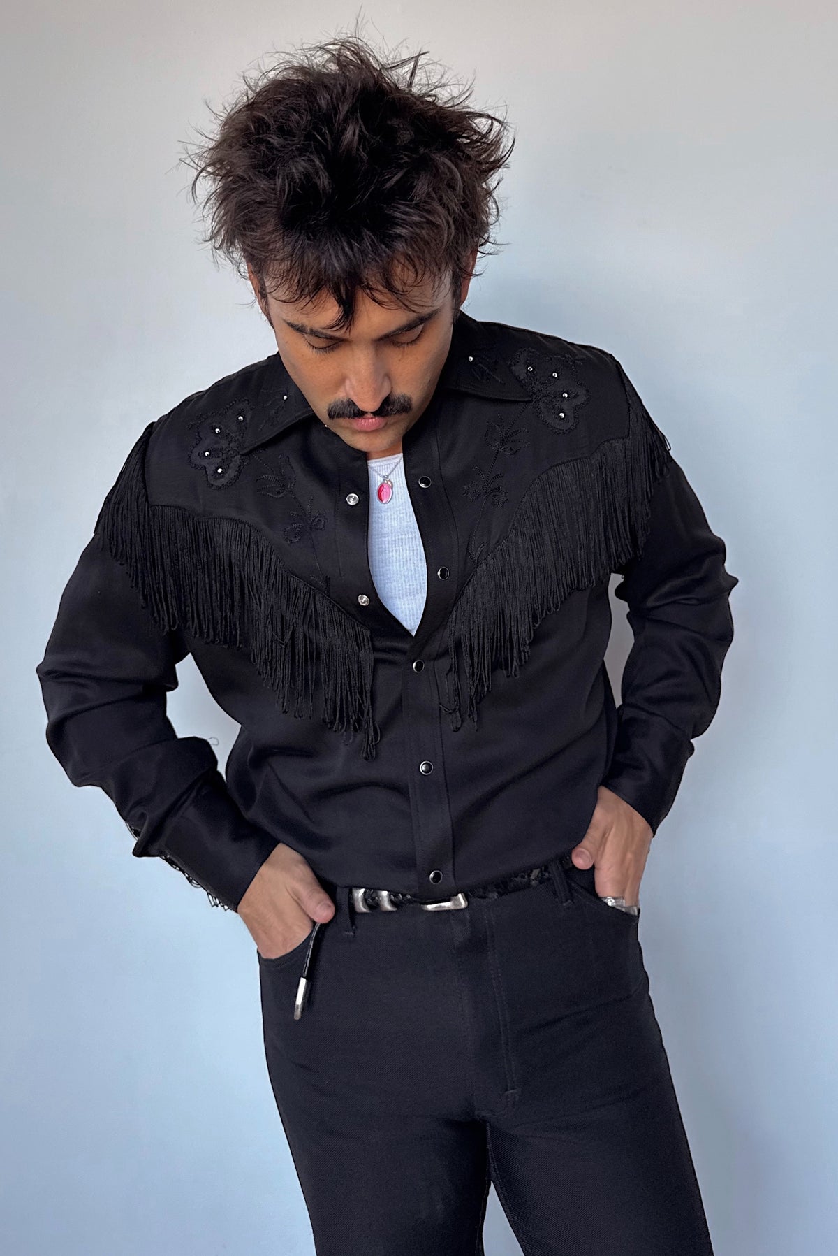 Front view of the H Bar C Taos black with black fringe western shirt worn with black pants.