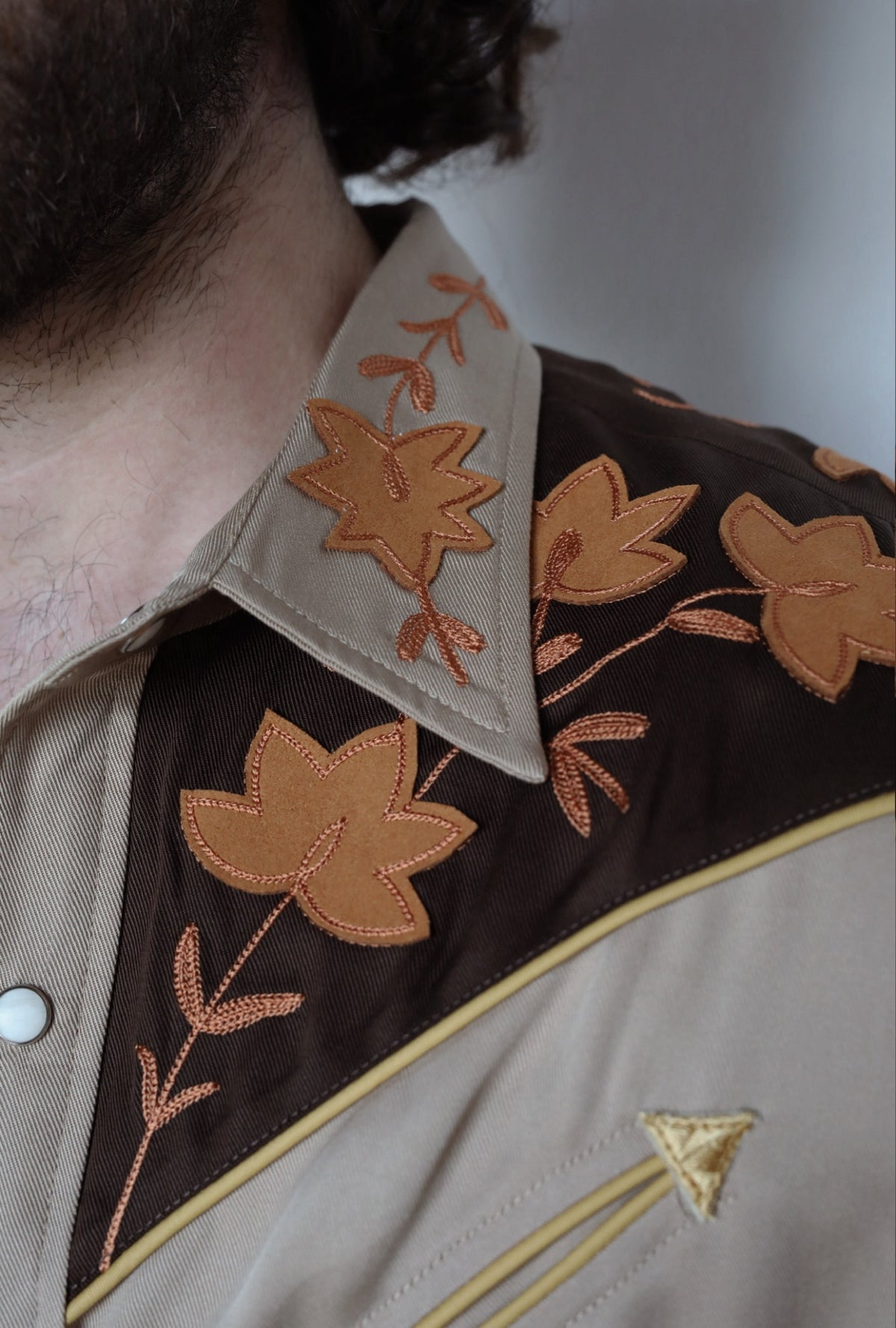 Close-up of the brown yoke, leaf embroidery, and gold arrow piping on the H Bar C Stowe western shirt.