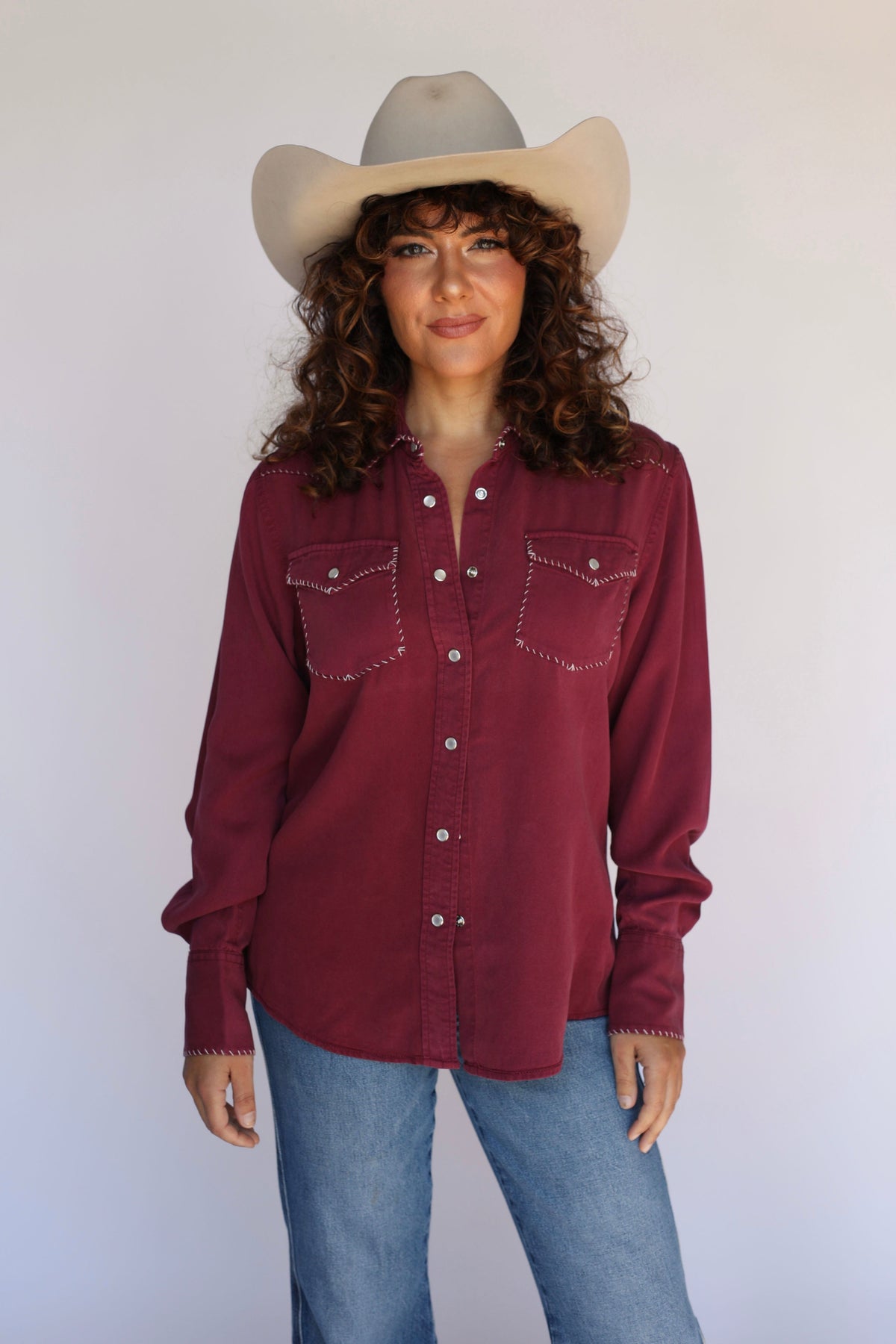 Front view of the H Bar C Brooklyn wine women's western shirt tucked into jeans.