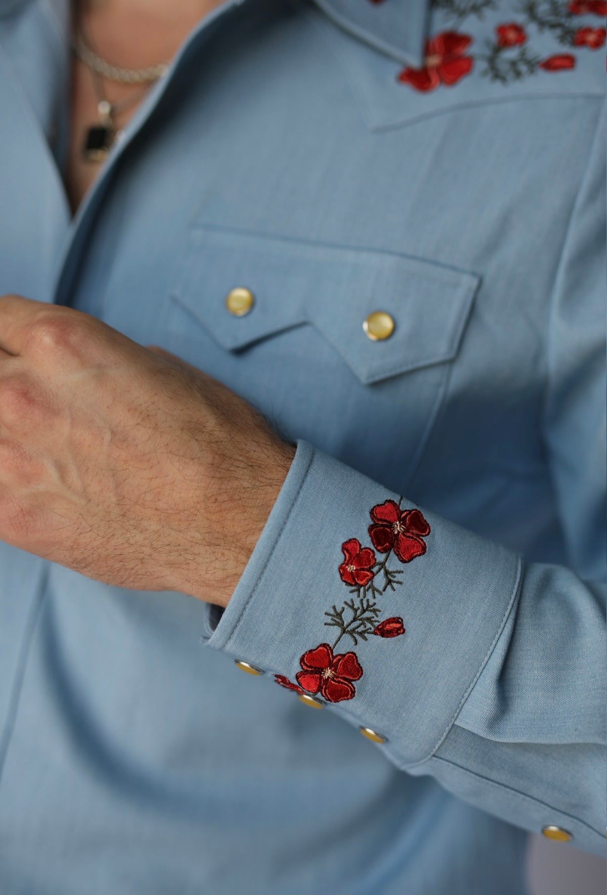 Detail of the embroidered snap cuff and chest pocket on the HBarC x Gibson Dove light blue western shirt.