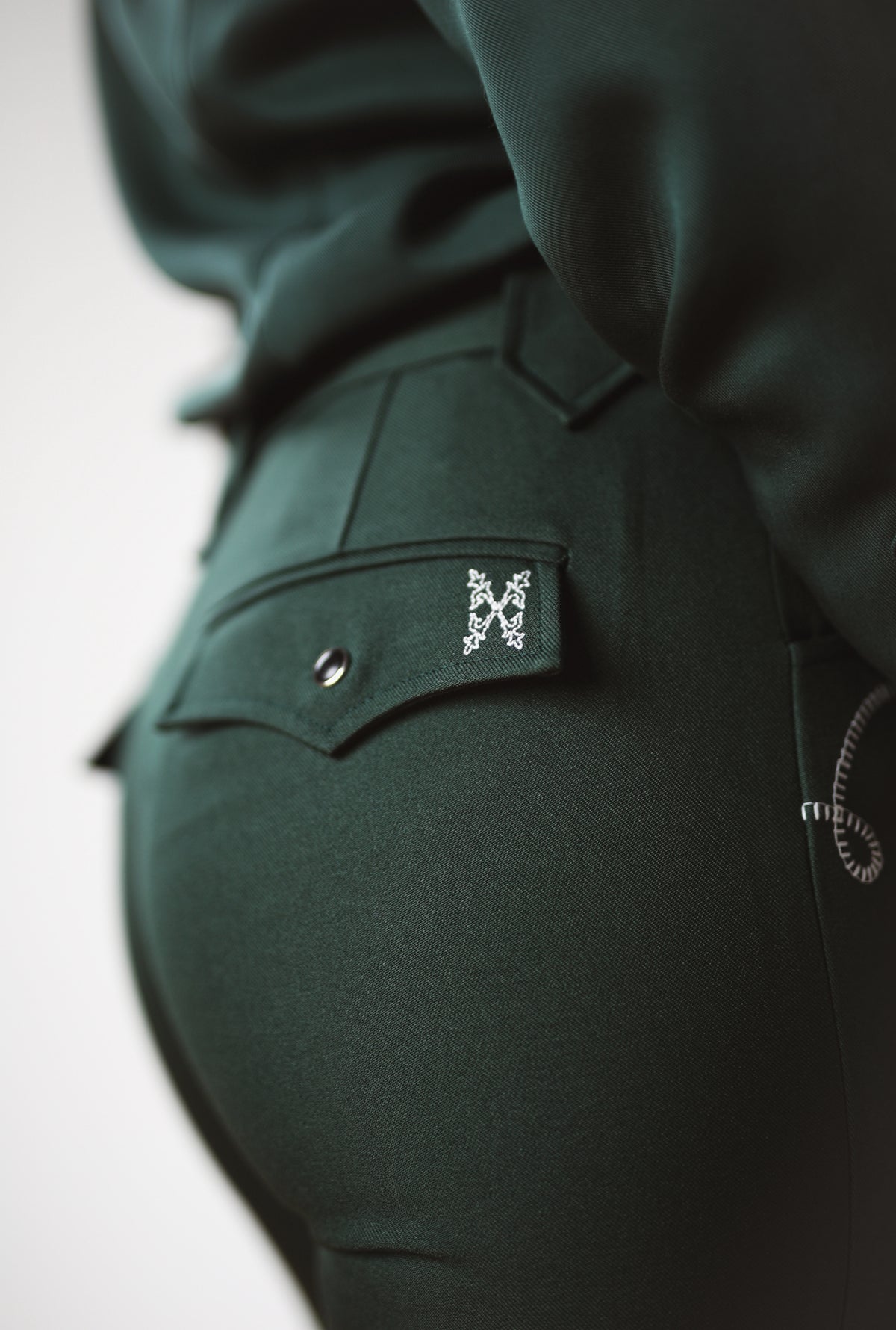 Close-up of the embroidered back pocket on the Tecovas x H Bar C green Birthday X pant.
