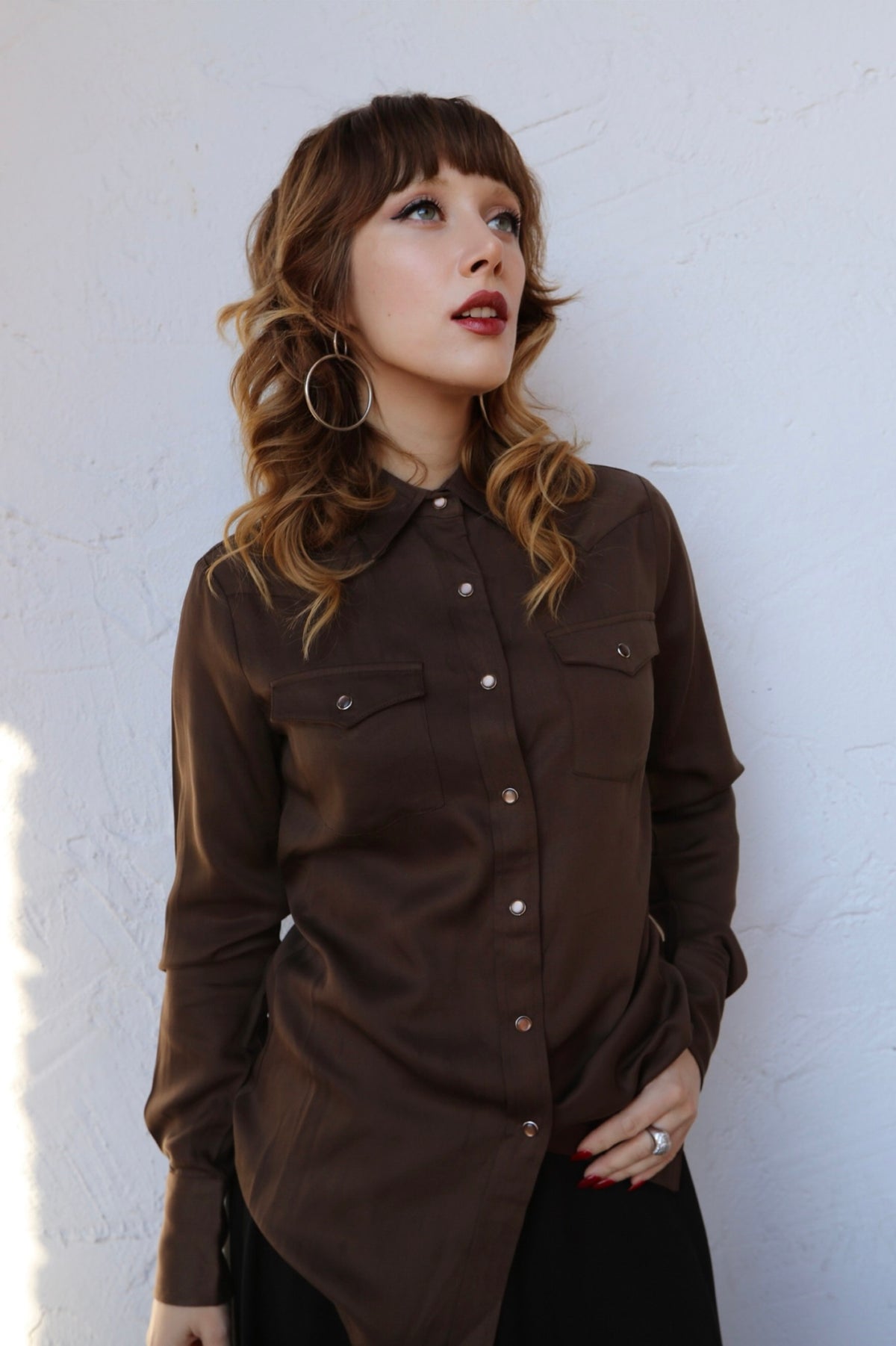 Woman wearing the H Bar C Denver women's shirt in chocolate brown, a classic Tencel pearl snap western shirt.