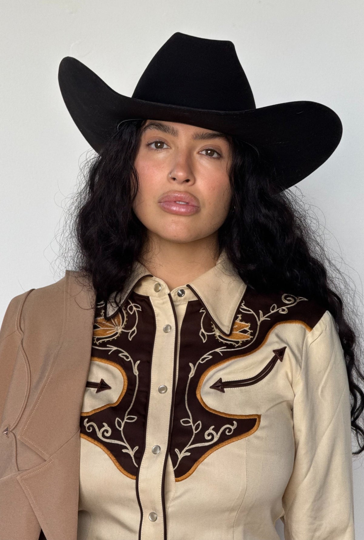 Woman in a black cowboy hat wearing the H Bar C Santa Barbara women's beige western shirt with brown embroidered yokes, a 1970s design.