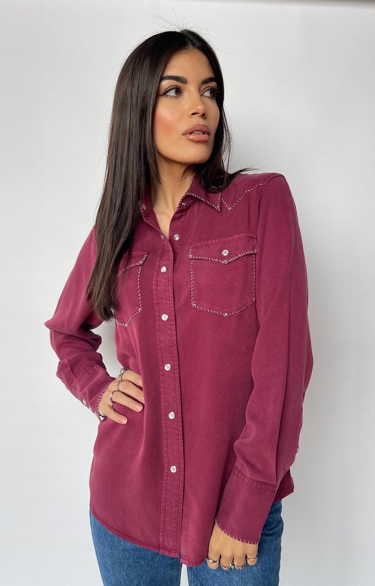 Woman with hand on hip in the H Bar C Brooklyn wine pearl snap western shirt.
