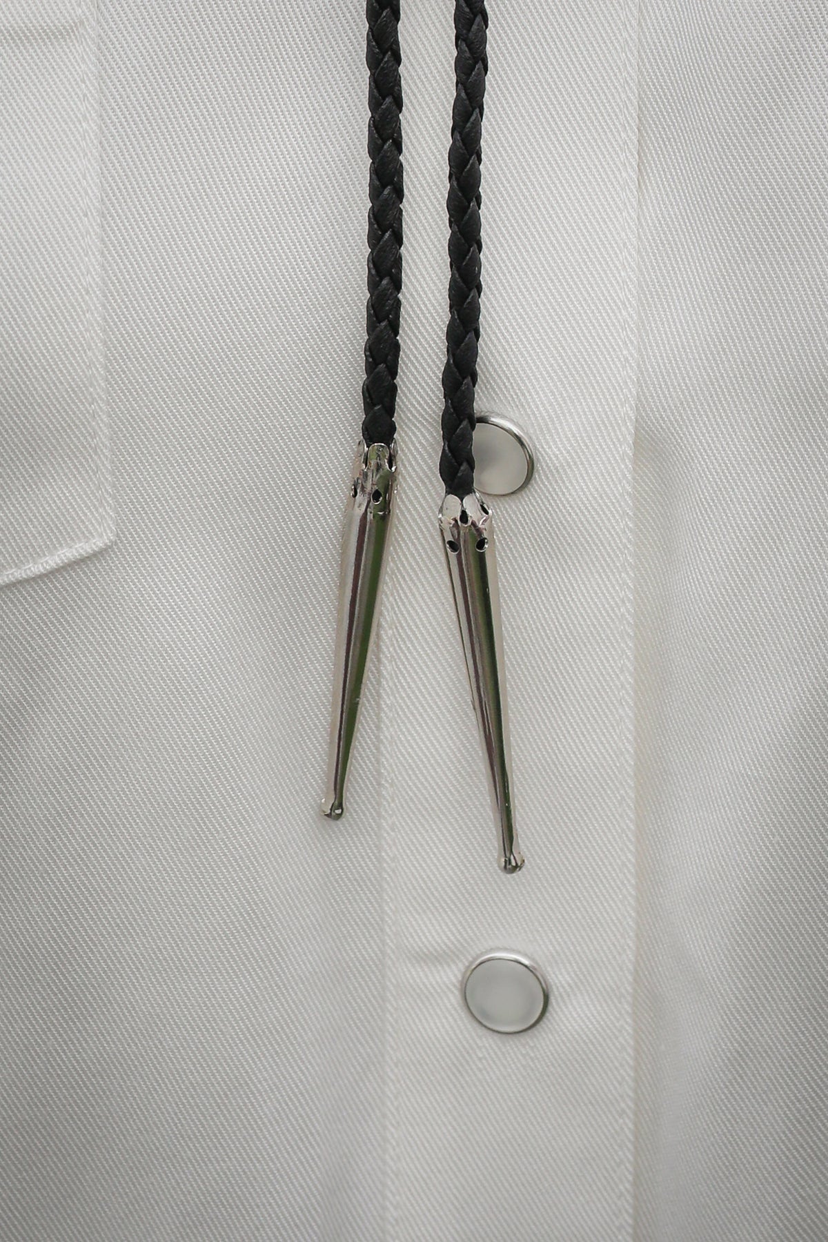 Close-up of the silver tips and black braided leather cord on the H Bar C cowboy boots bolo tie.