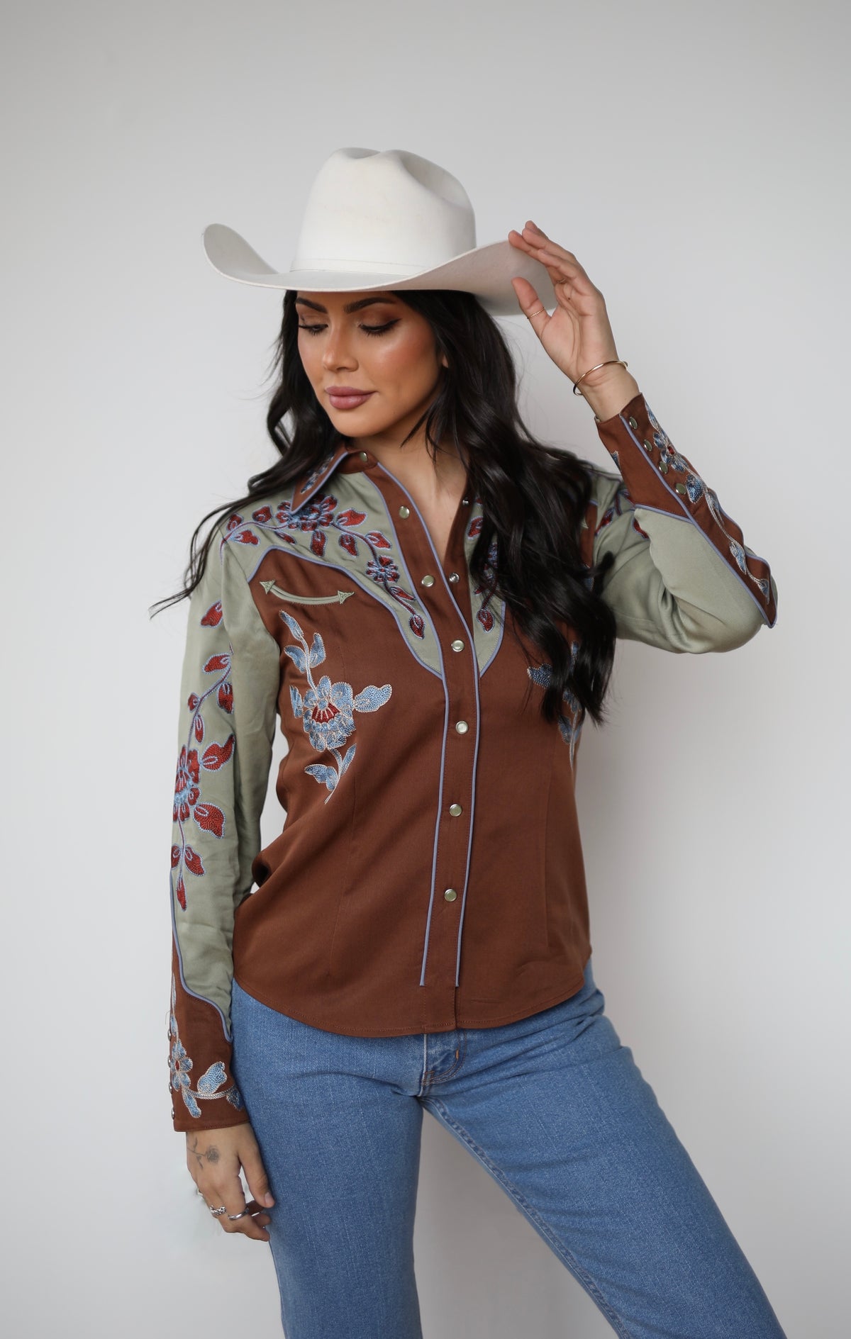 Woman tipping her white cowboy hat in the H Bar C San Antonio women's embroidered rodeo shirt.