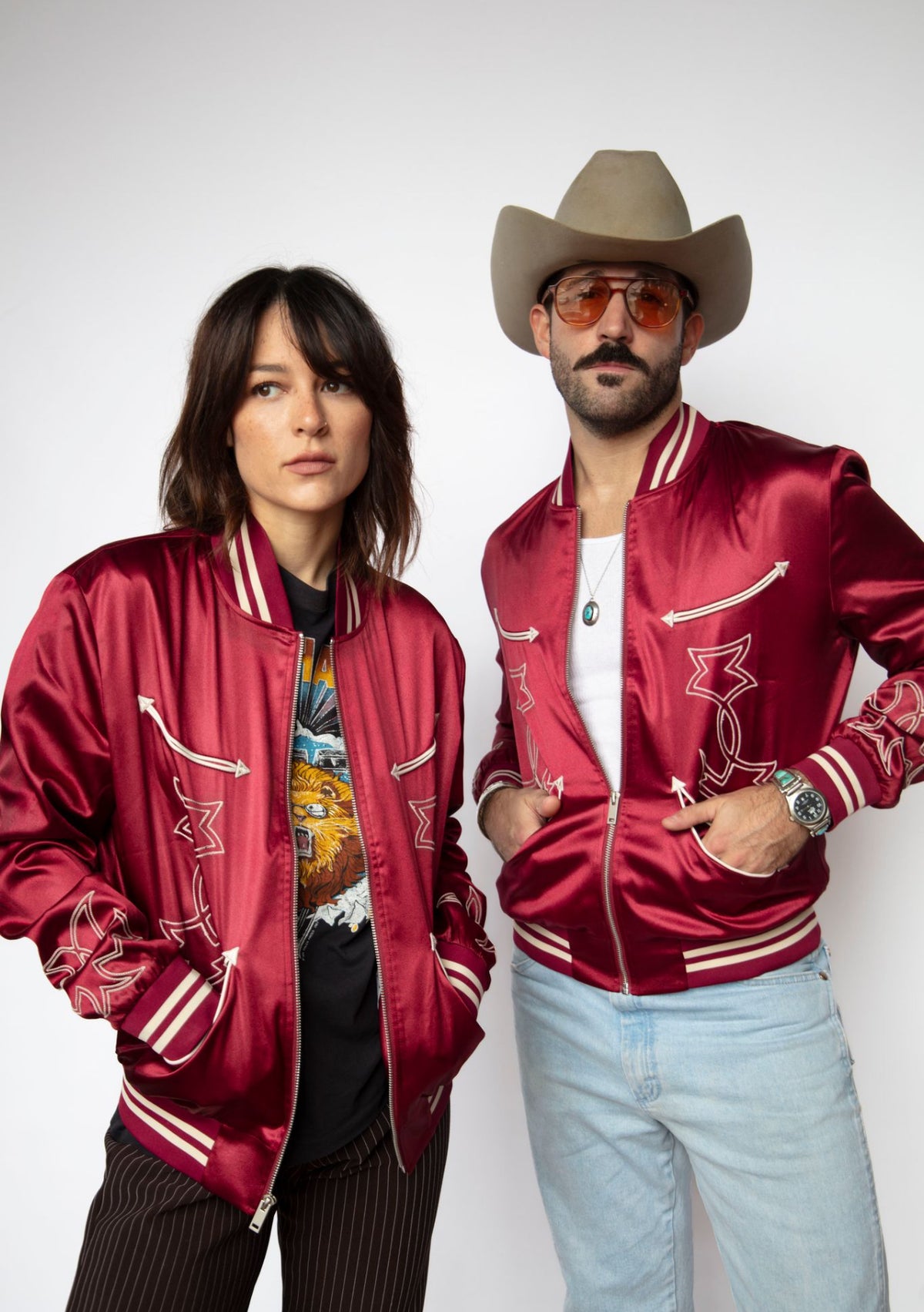 Couple wearing matching H Bar C Odessa red tour jackets, unisex western satin bomber.
