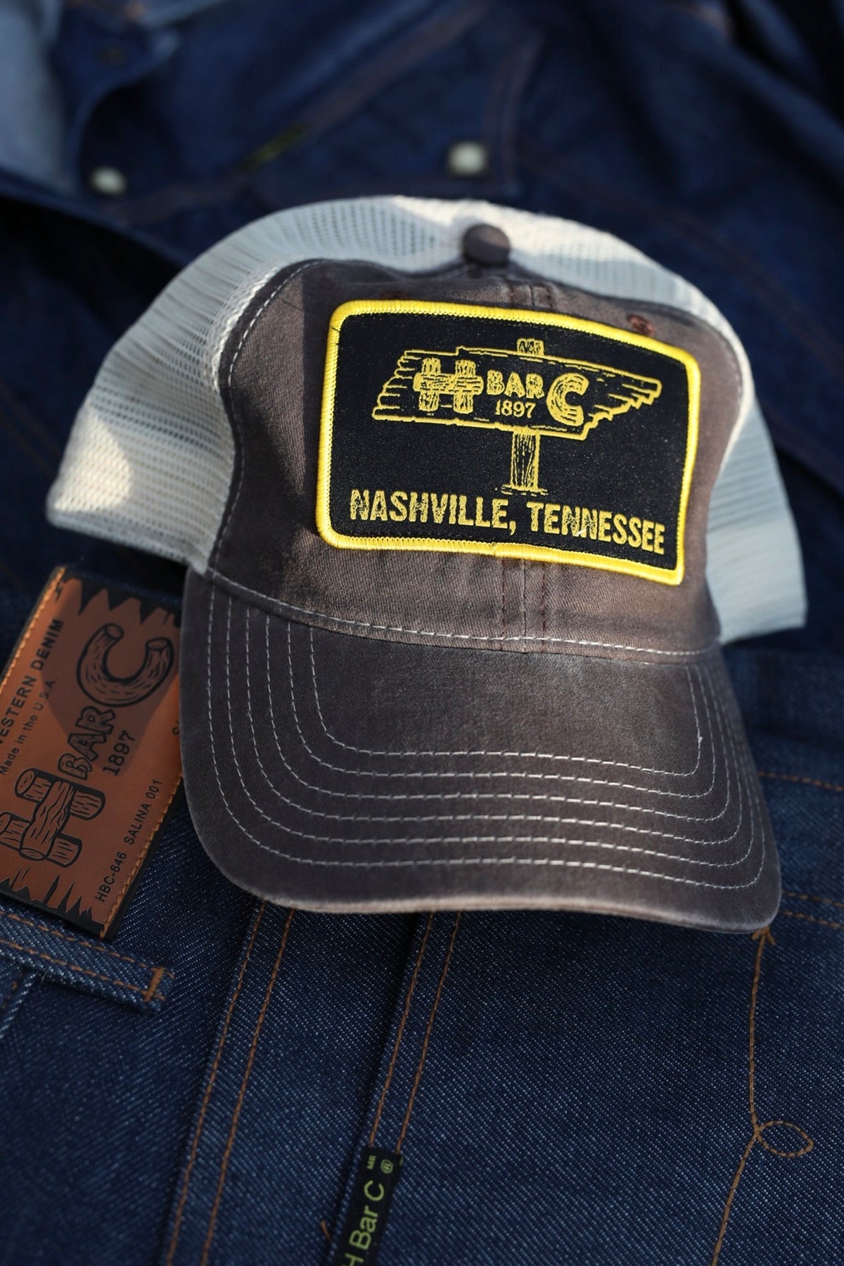 H Bar C TN Signpost mesh trucker hat in brown with a yellow Nashville, Tennessee signpost patch.