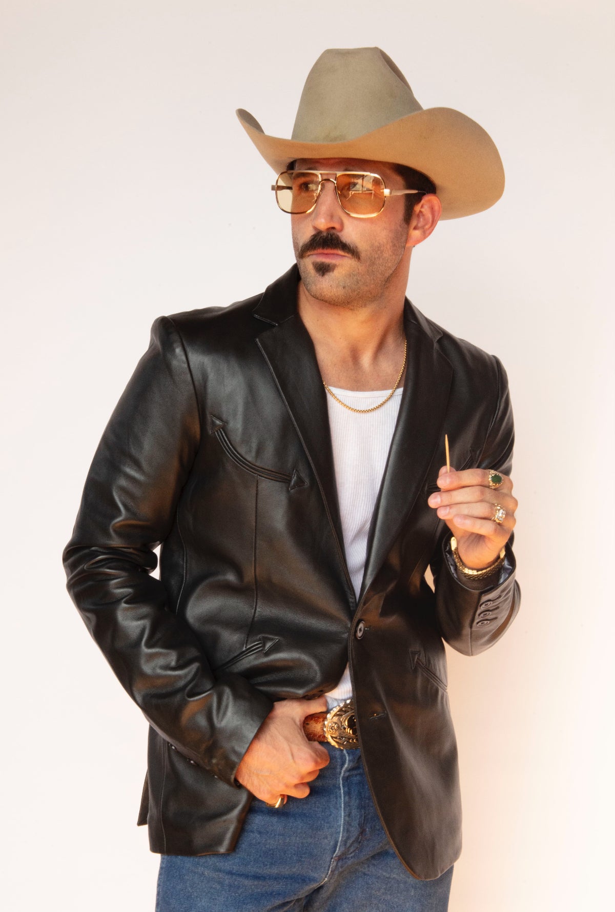 Front view of the H Bar C Carson men's black leather jacket with jeans and a western buckle.