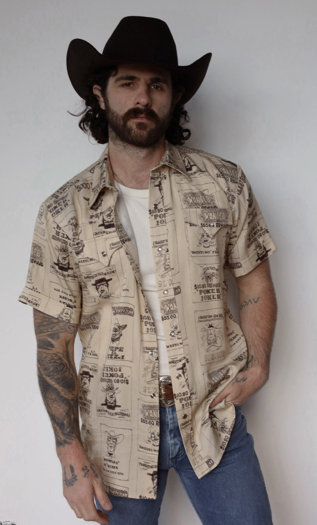 Three-quarter view of the H Bar C Newport Tumbleweed short sleeve pearl snap shirt with jeans.