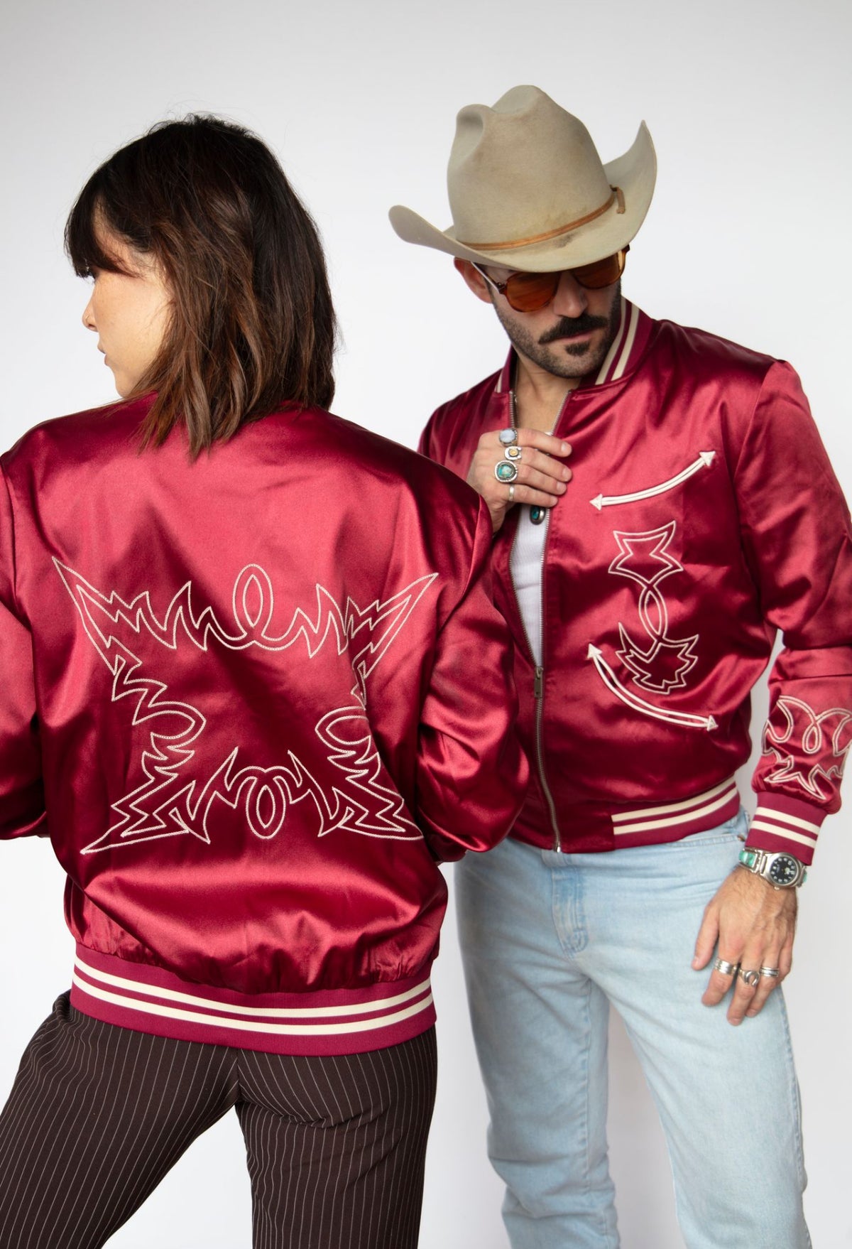 Woman and man both wearing the H Bar C Odessa unisex red satin tour jacket.
