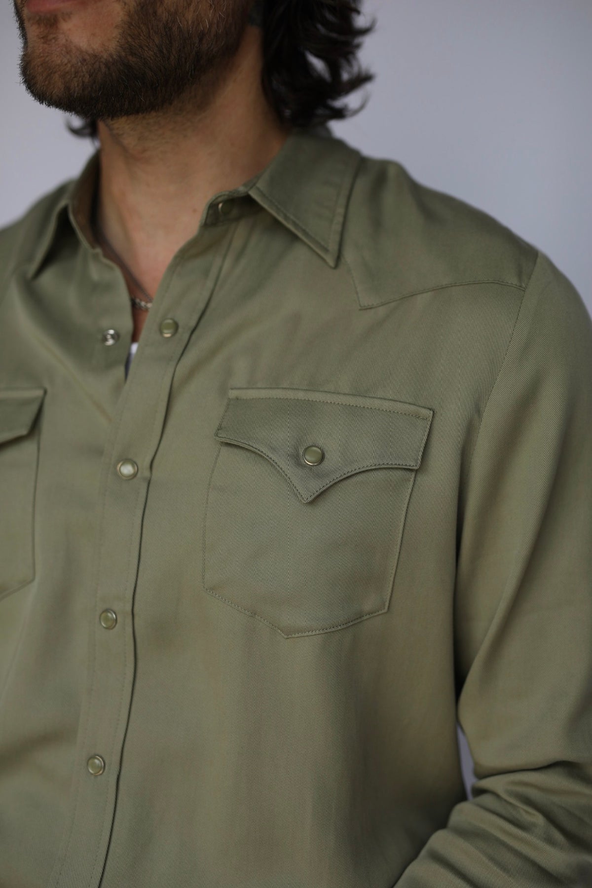 Close-up of the chest pocket, collar, and snaps on the H Bar C Denver men's green western shirt.