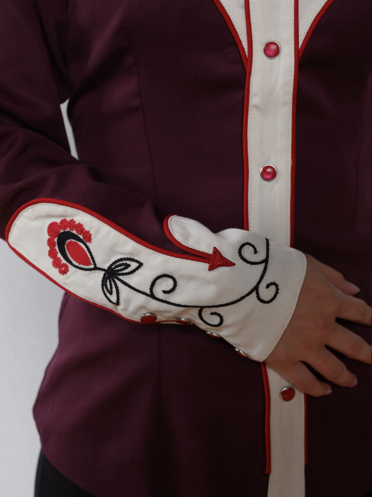 Cuff detail of the H Bar C San Jose burgundy shirt with cream embroidered cuff and red snaps.