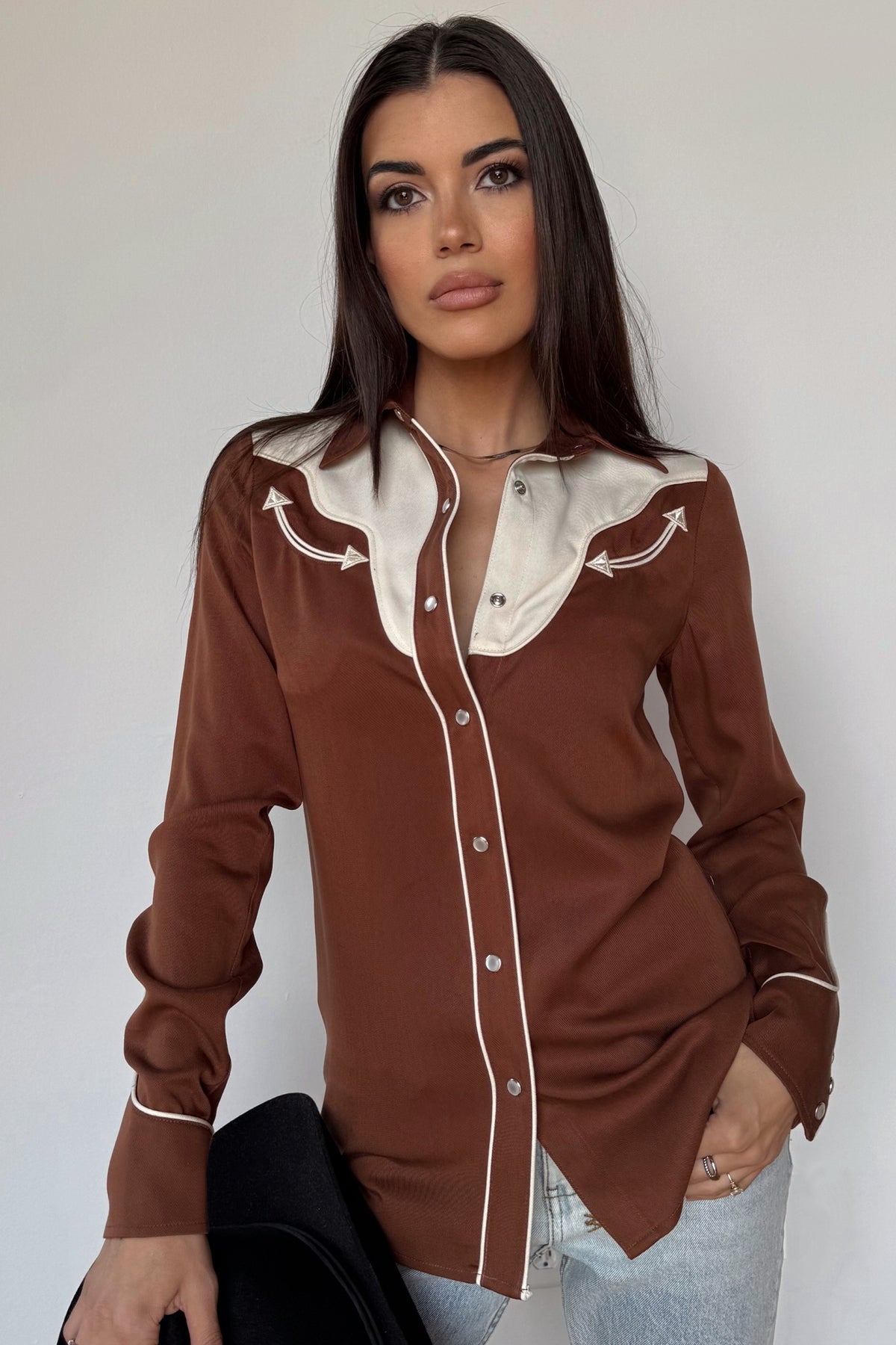Woman wearing the H Bar C San Juan women's shirt in brown with a cream yoke and piping.
