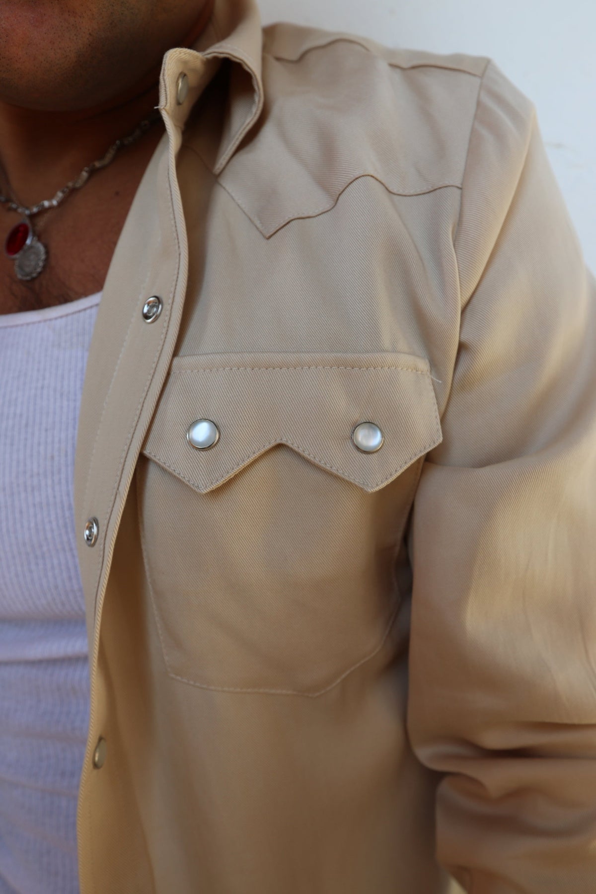 Close-up of the sawtooth pocket and pearl snaps on the H Bar C Kansas City beige western shirt.