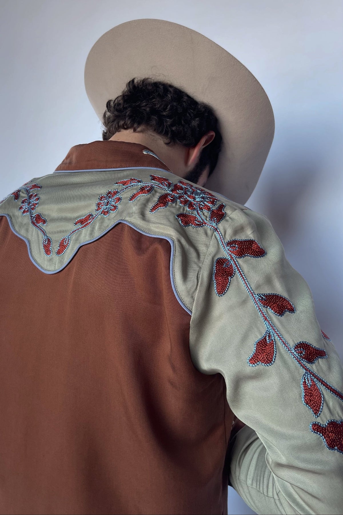 Shoulder detail of the H Bar C San Antonio brown western shirt with sage yoke and red floral chain stitch embroidery.