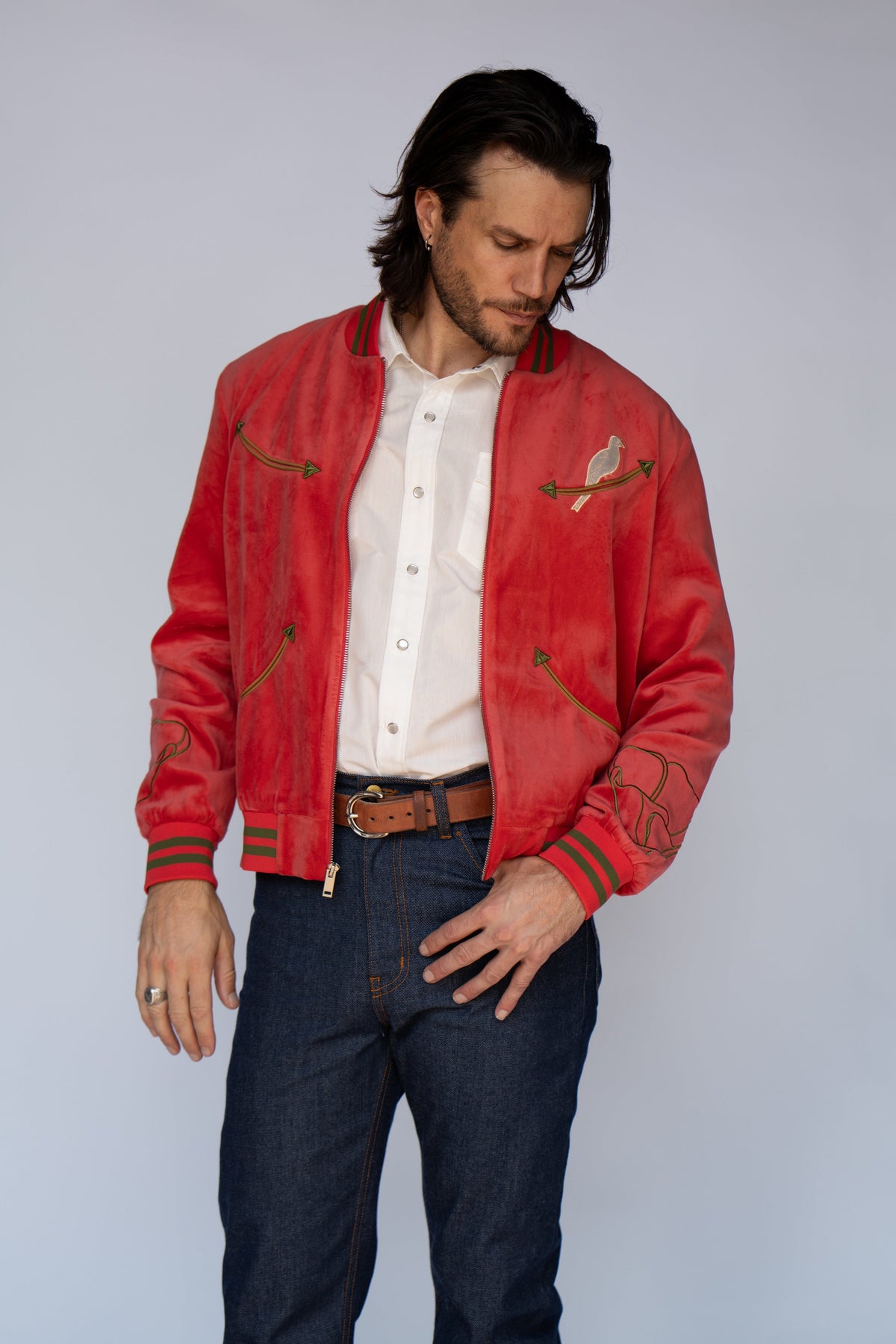 Front view of the HBarC x Gibson Dove red tour jacket worn over a white shirt with jeans.