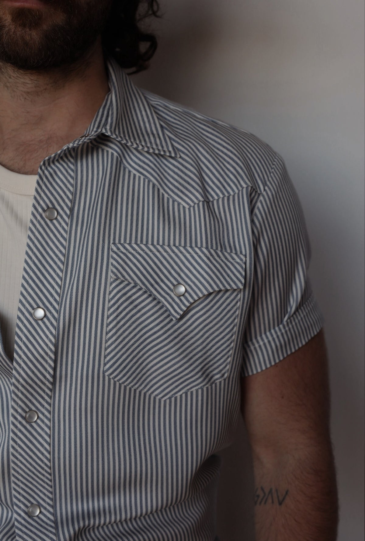 Close-up of the pinstripe fabric, pearl snaps, and pointed pocket flap on the H Bar C Newport gray striped shirt.