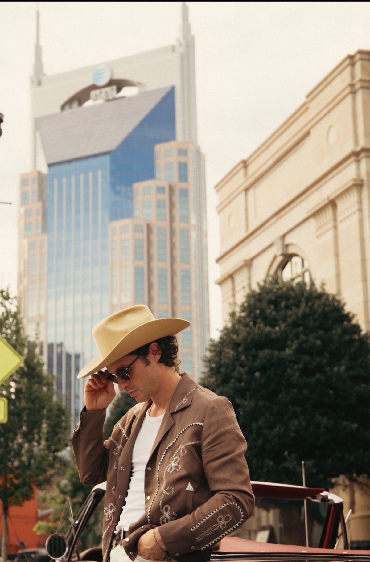 Man in a cowboy hat wearing the H Bar C Bolero cocoa jacket in front of the Nashville skyline.