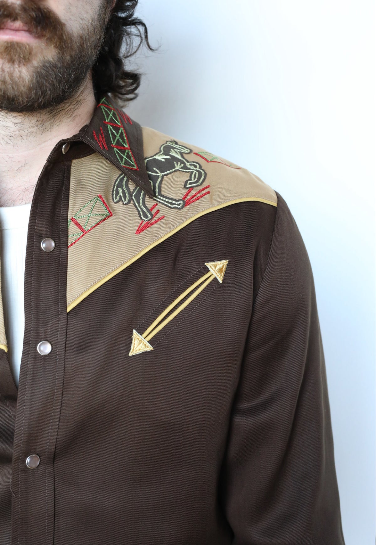 Close-up of the tan yoke embroidery and arrow on the H Bar C Bozeman brown western shirt.