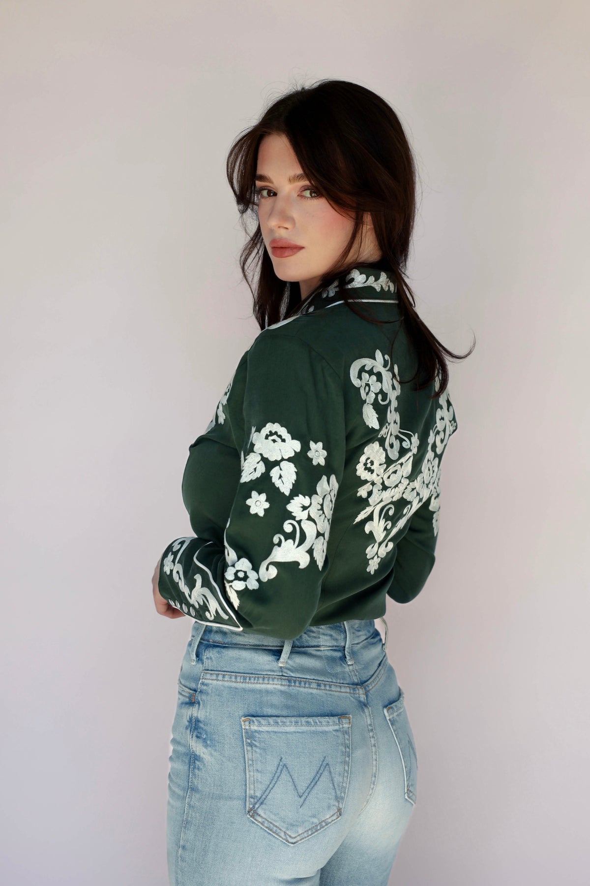 Side view of the H Bar C Fort Worth green shirt showing white floral sleeve embroidery.