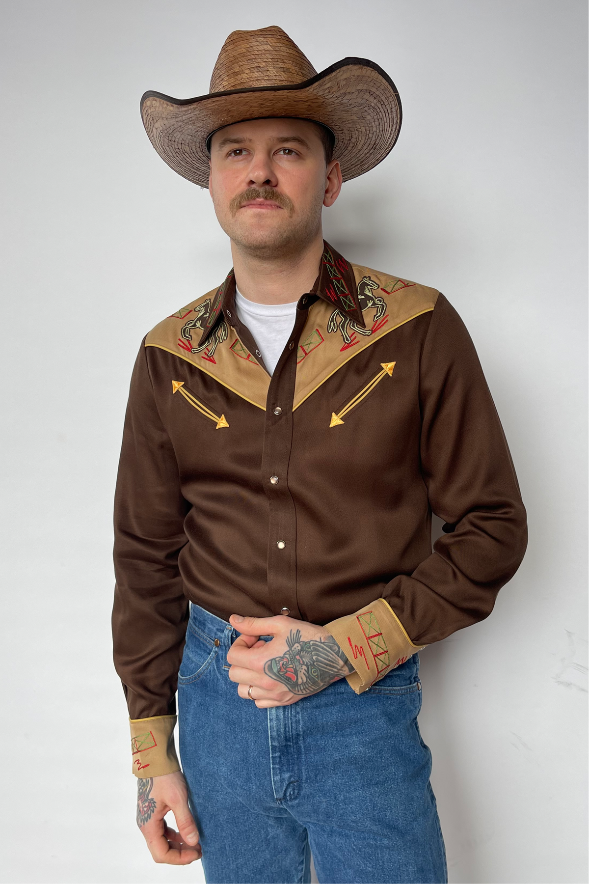 Man in a cowboy hat wearing the H Bar C Bozeman shirt in brown with tan yokes, arrow details, and embroidered cuffs.
