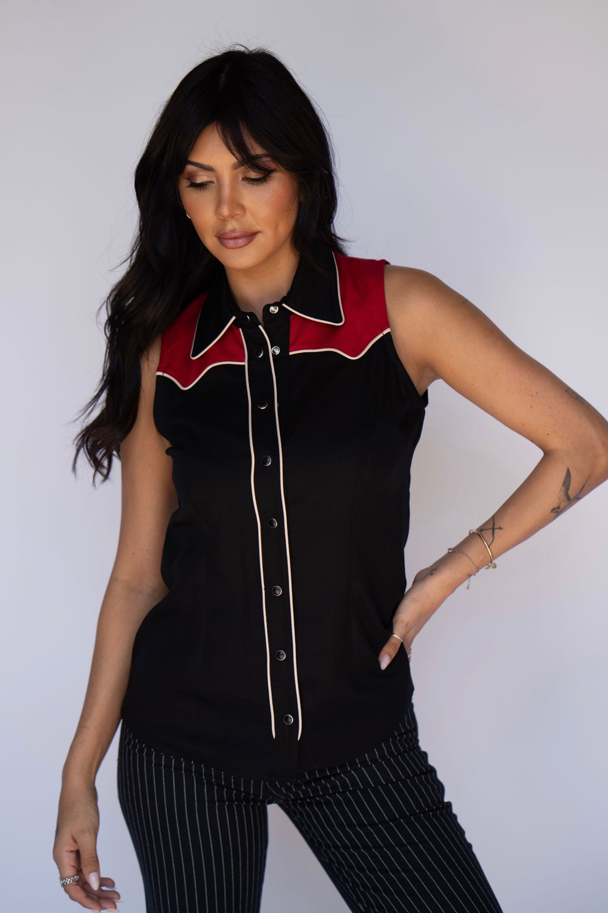 Woman with hand on hip in the H Bar C Atlanta black and red sleeveless western top.