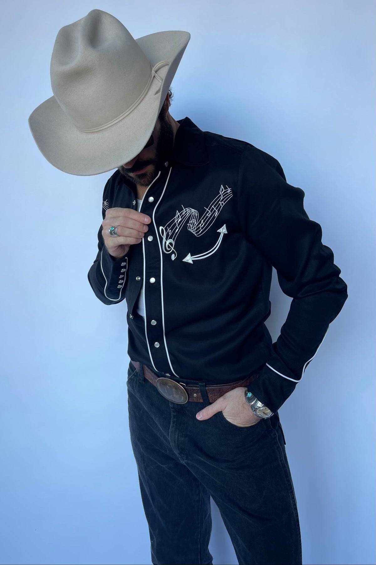 Man looking down in the H Bar C Nashville embroidered black western shirt.