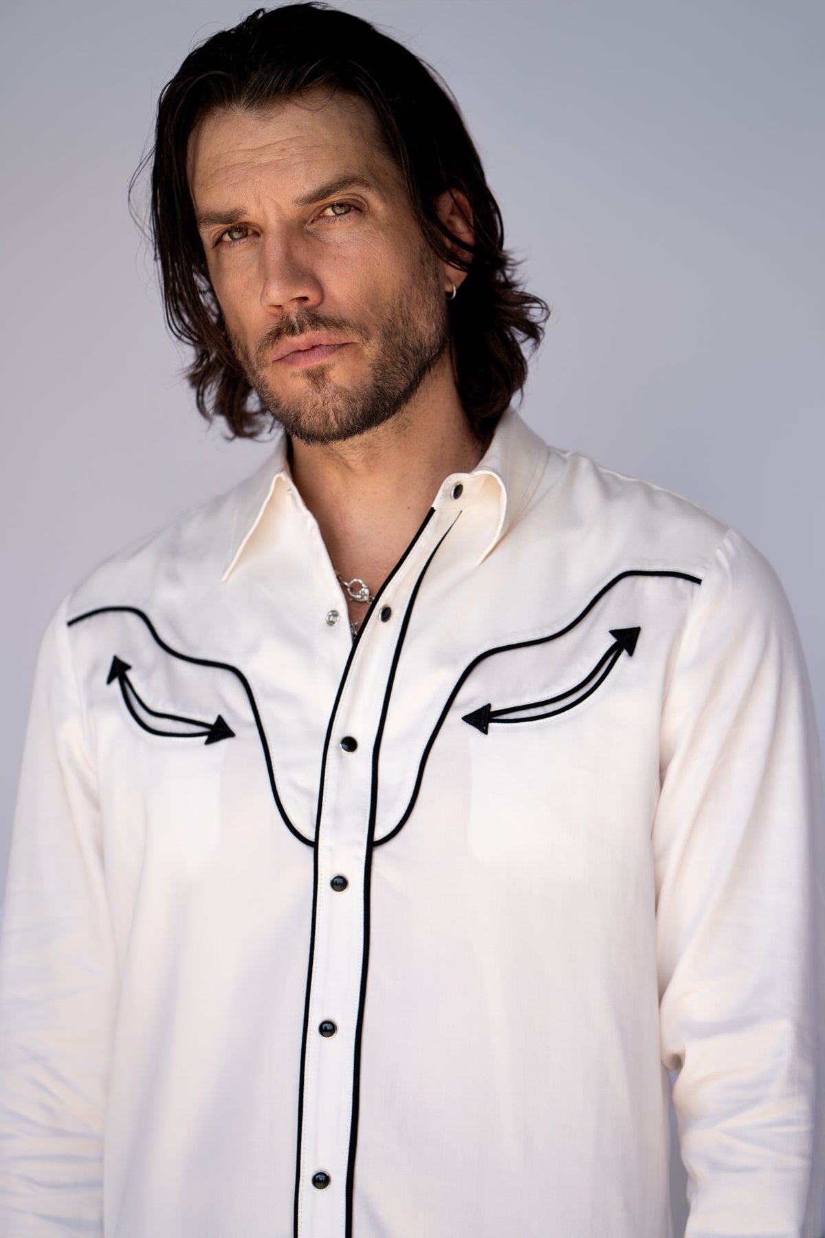 Man wearing the H Bar C San Fernando white Tencel shirt with black piped smile yokes and pearl snaps.