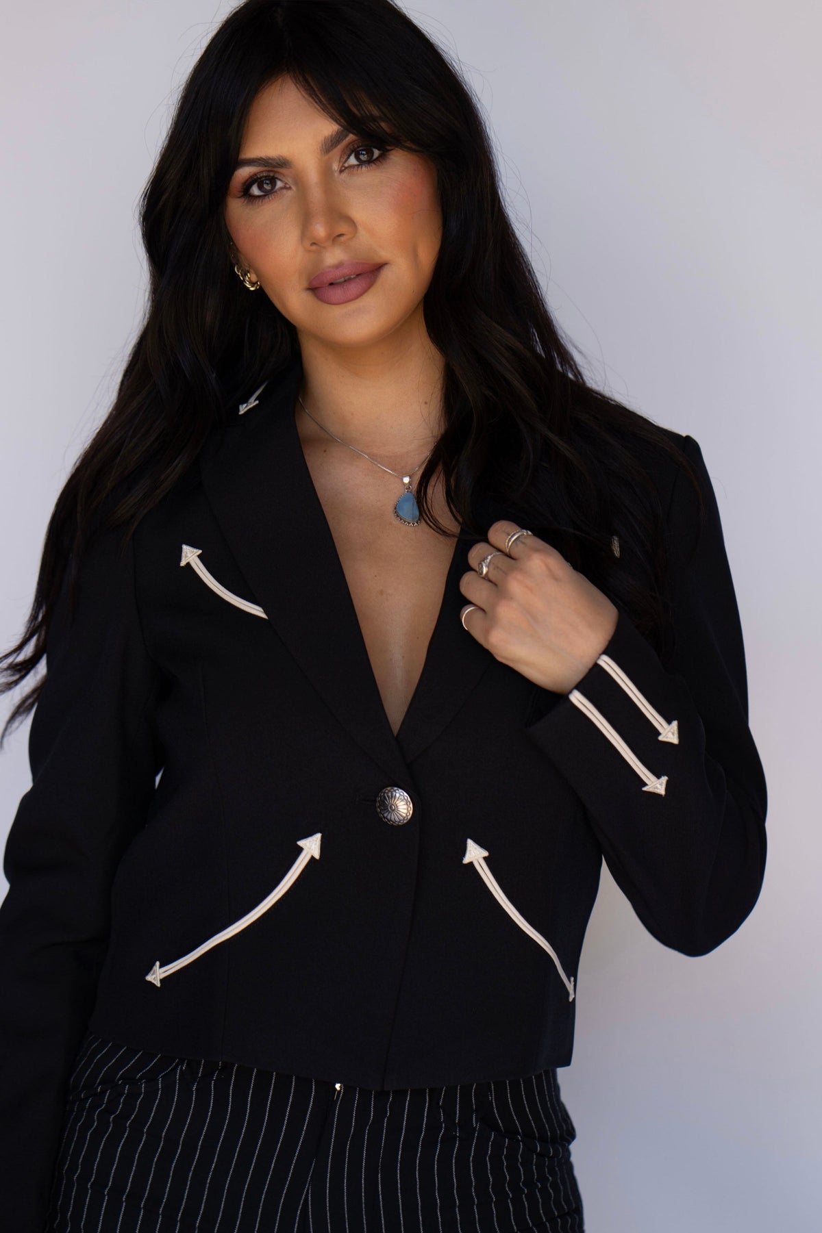Close-up of the H Bar C Calamity women's black jacket with cream arrow smile pockets and cuff details.