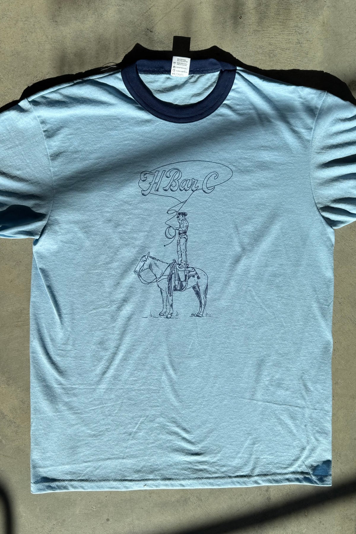 H Bar C x Kate Snake Art Standing on Horse blue ringer tee with a hand drawn cowboy standing on a horse.