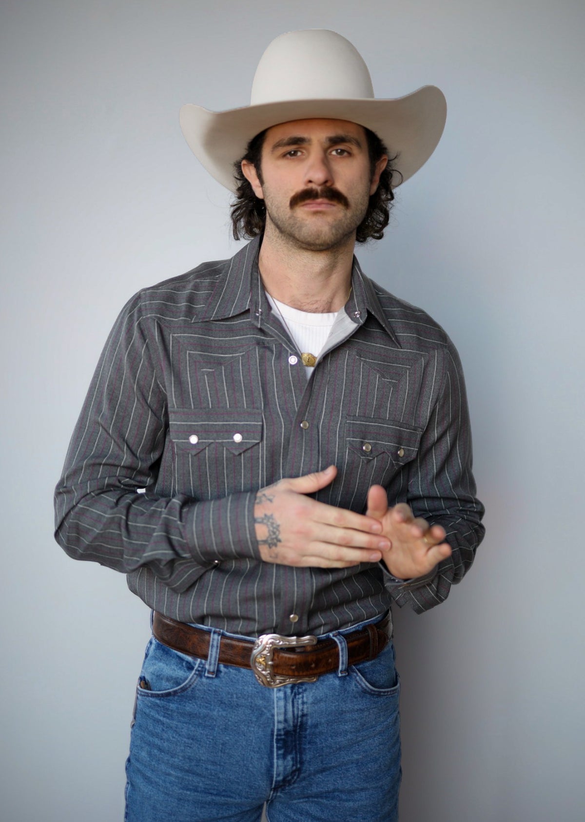 Front view of the H Bar C Tiger charcoal striped snap shirt tucked into jeans.