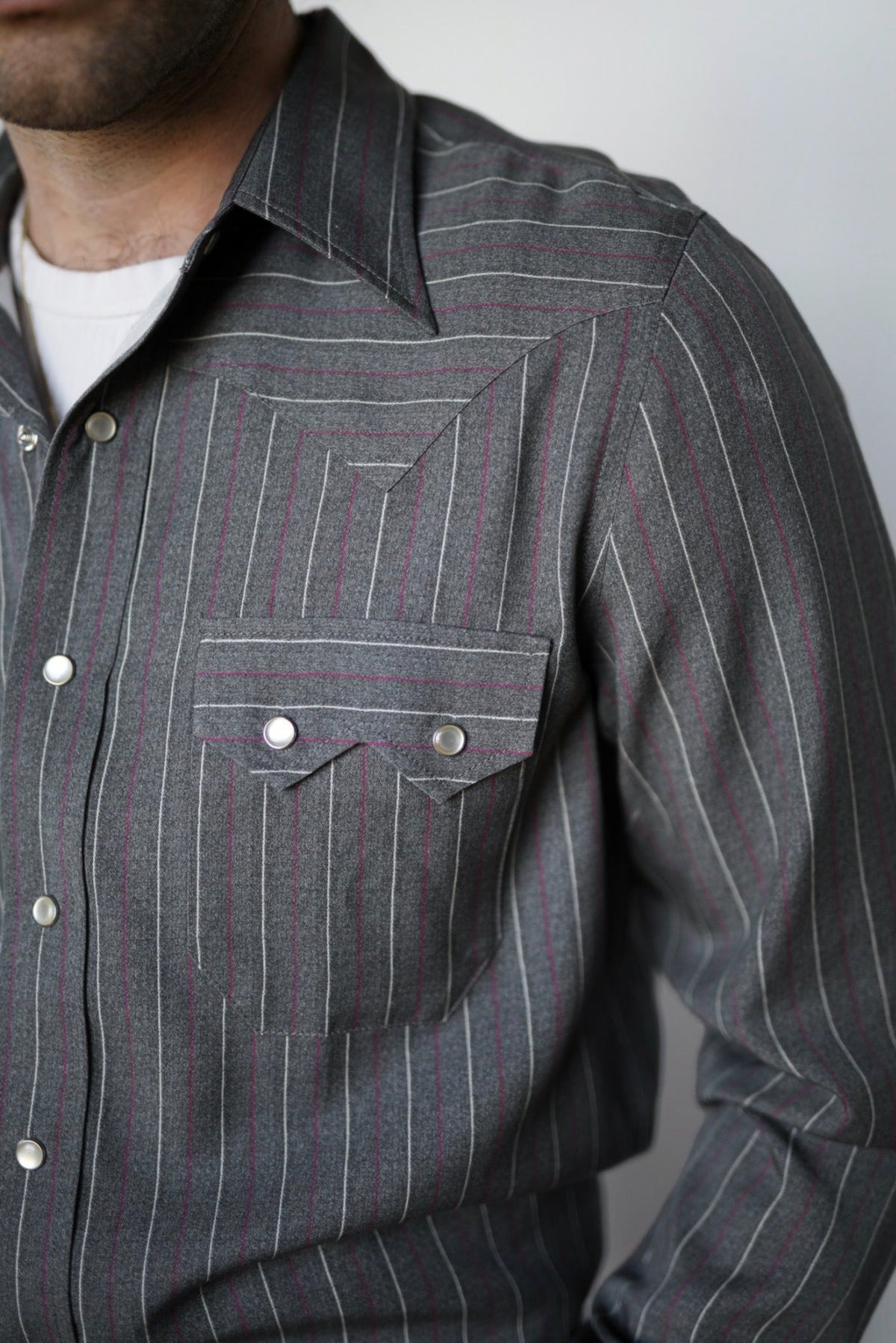 Close-up of the striped fabric, pocket flap, and snaps on the H Bar C Tiger shirt.