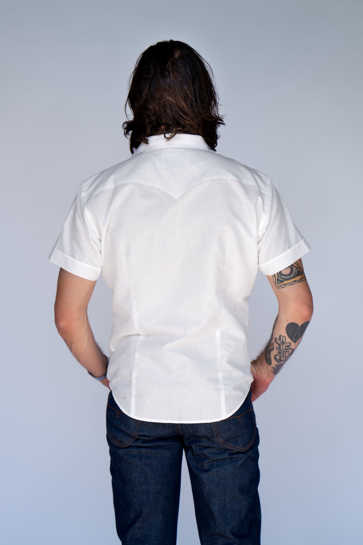 Back view of the H Bar C Newport Jacquard white western shirt tucked into jeans.
