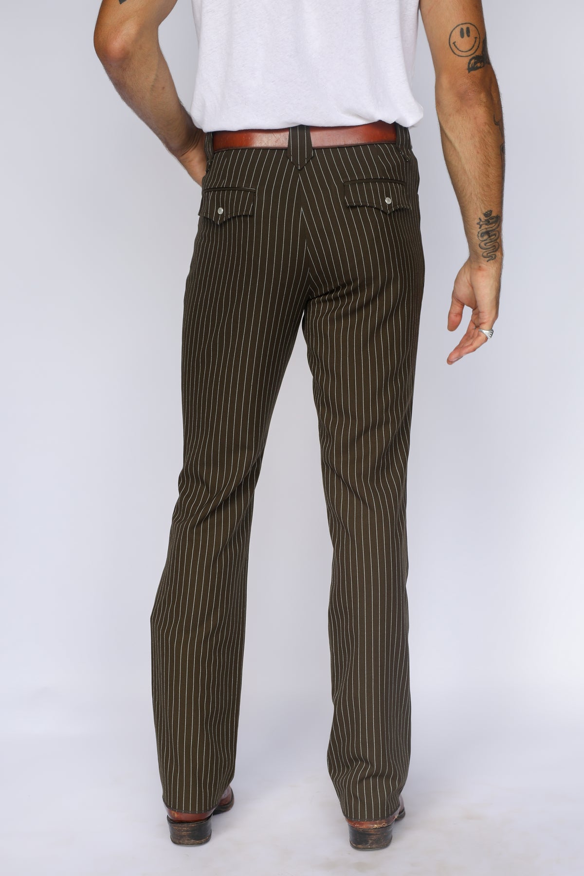 Back view of the H Bar C Bakersfield brown pinstripe pants from the waist down with cowboy boots.