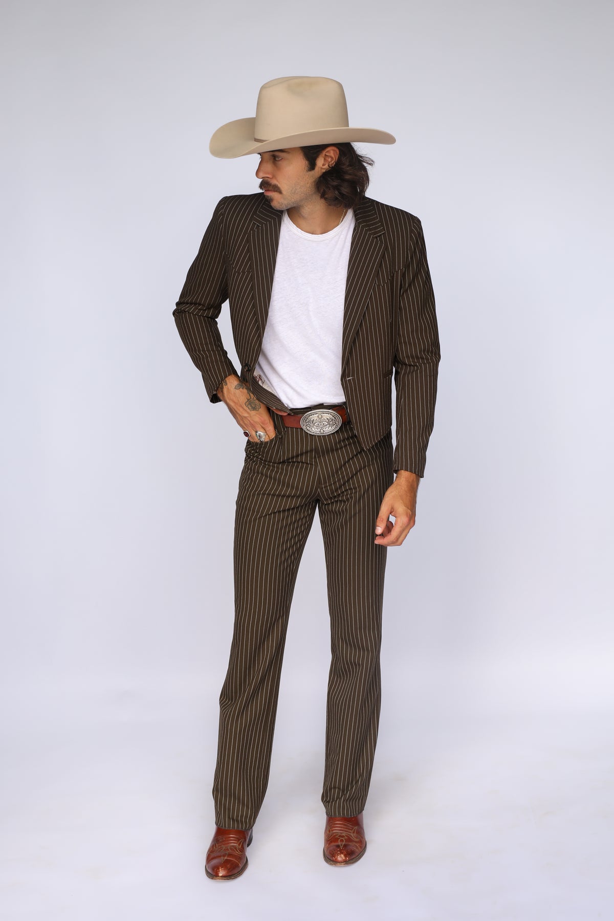 Front view of the H Bar C Bakersfield brown pinstripe western jacket worn open over a white tee with matching pants.