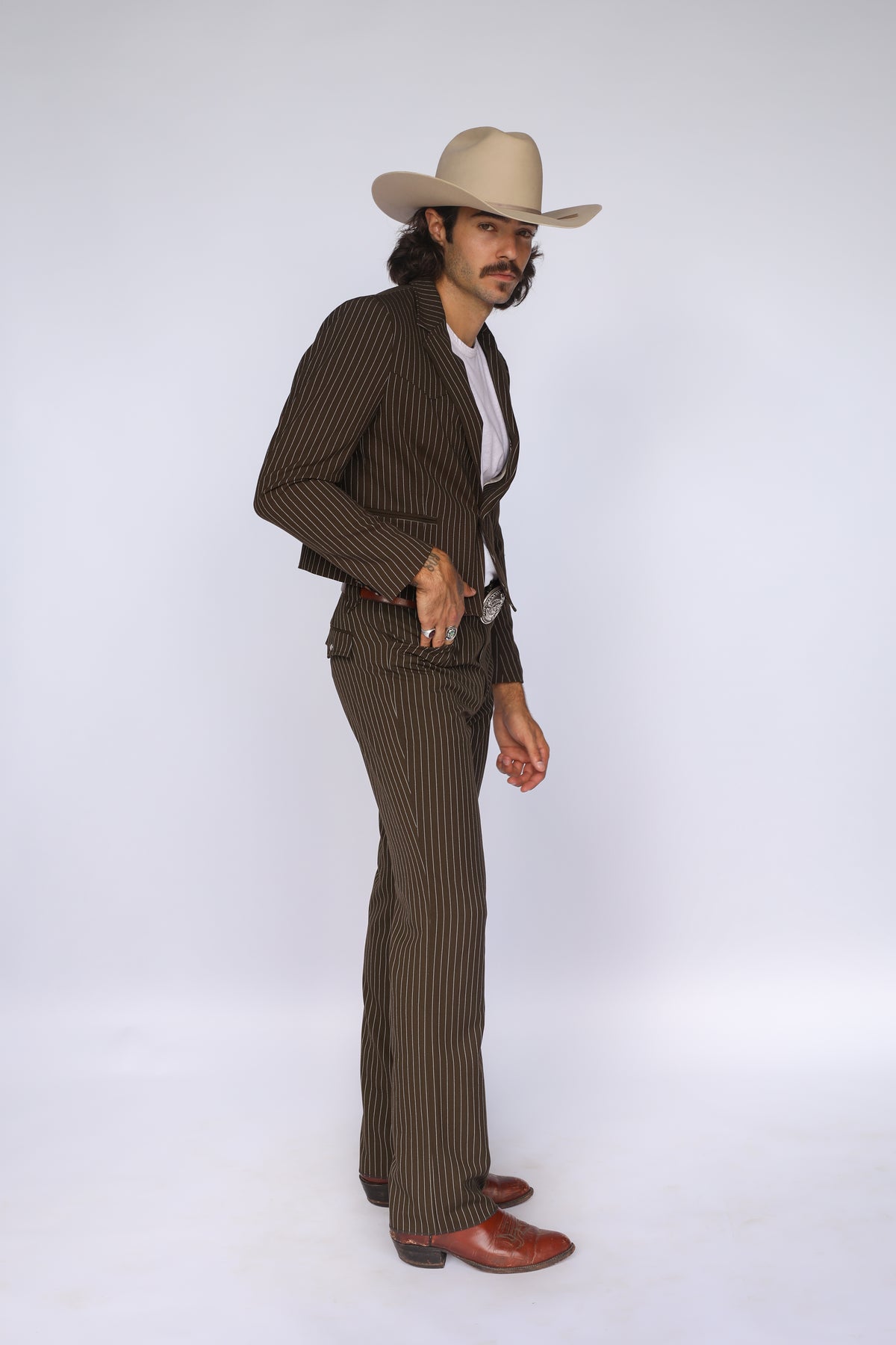 Three-quarter view of the H Bar C Bakersfield brown pinstripe western suit with cream cowboy hat and boots.